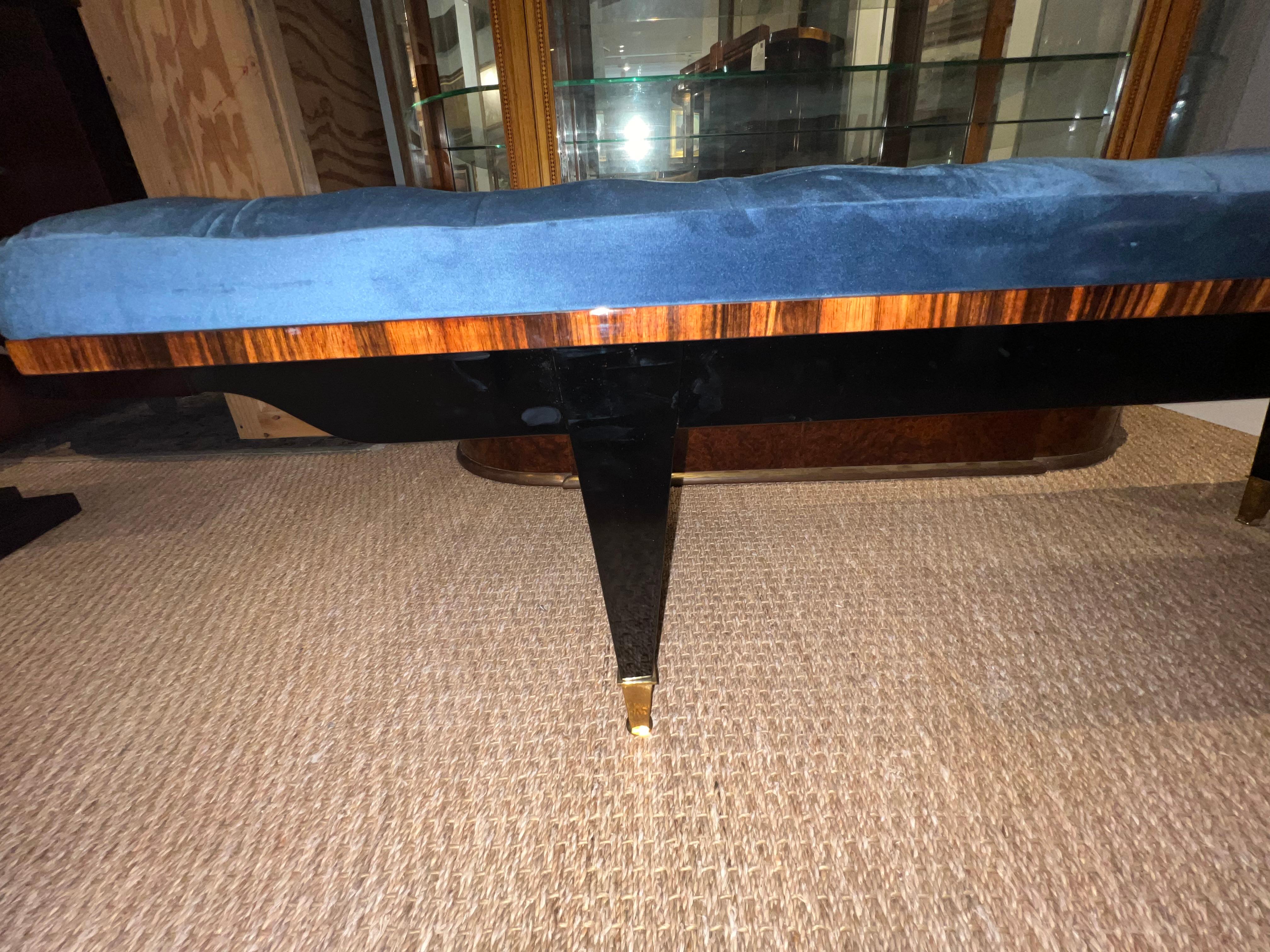 Art Deco French bench is made out of Macassar wood and newly re-upholstered with blue velvety fabric. Bench seat  is elevated by  four elongated legs made out of ebonized wood with a brass decorative tips.
Condition is perfect. Restored 

French,