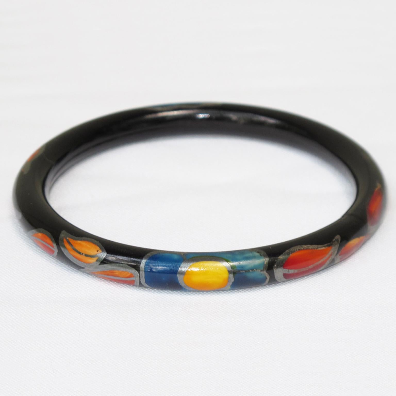 Voici un joli bracelet en celluloïd Art Déco français des années 1920. Il présente une forme de tube creux léger avec un motif de feuilles et de fleurs sur le pourtour du bracelet. 
La technique du bracelet creux est une technique ancienne appliquée
