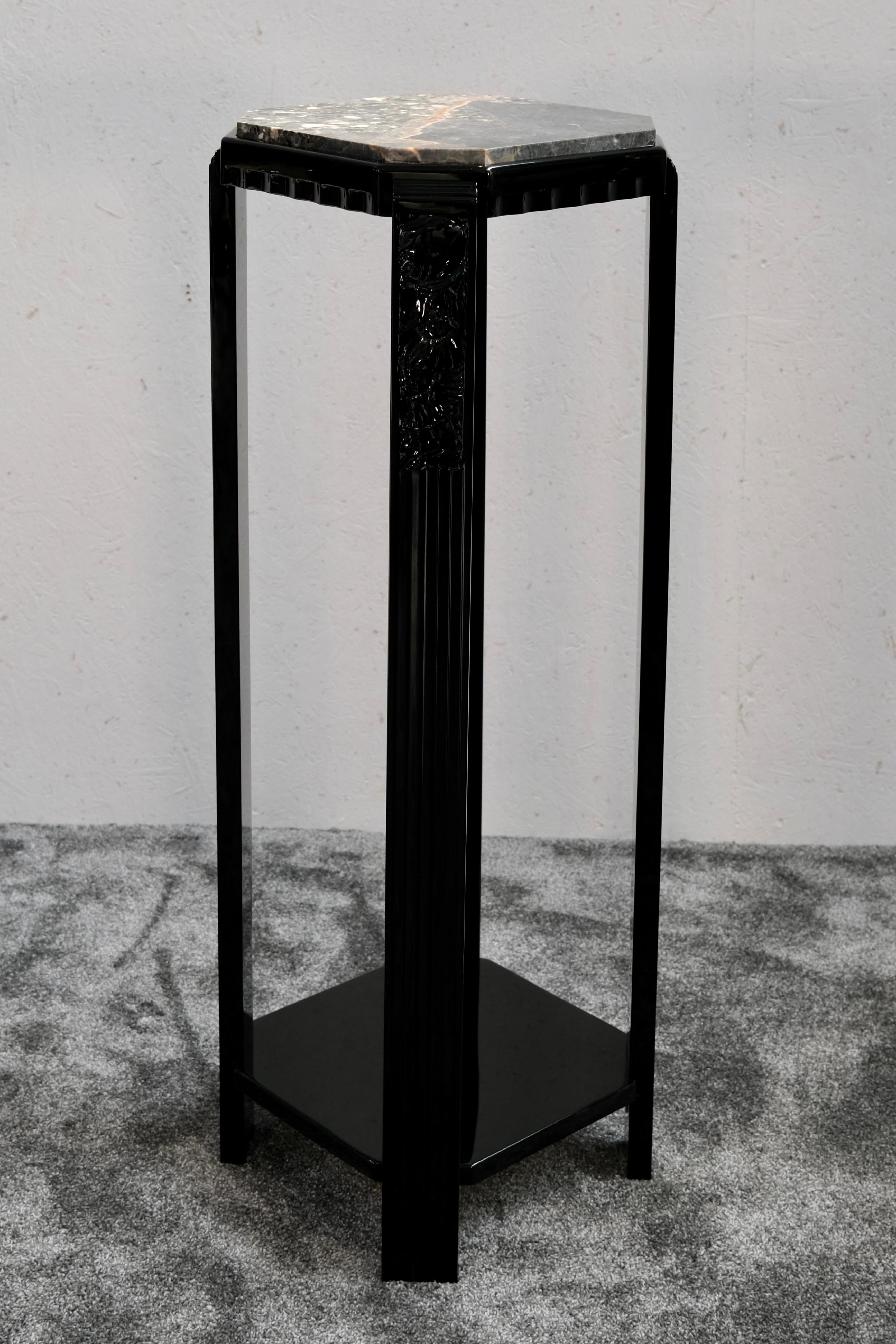 Pedestal francés Art Decó lacado en negro con tapa de mármol de Portoro, fabricado en Francia hacia 1930. La losa hexagonal de mármol presenta un espectacular veteado natural en tonos grises, naranjas y blancos, y descansa sobre un marco de madera