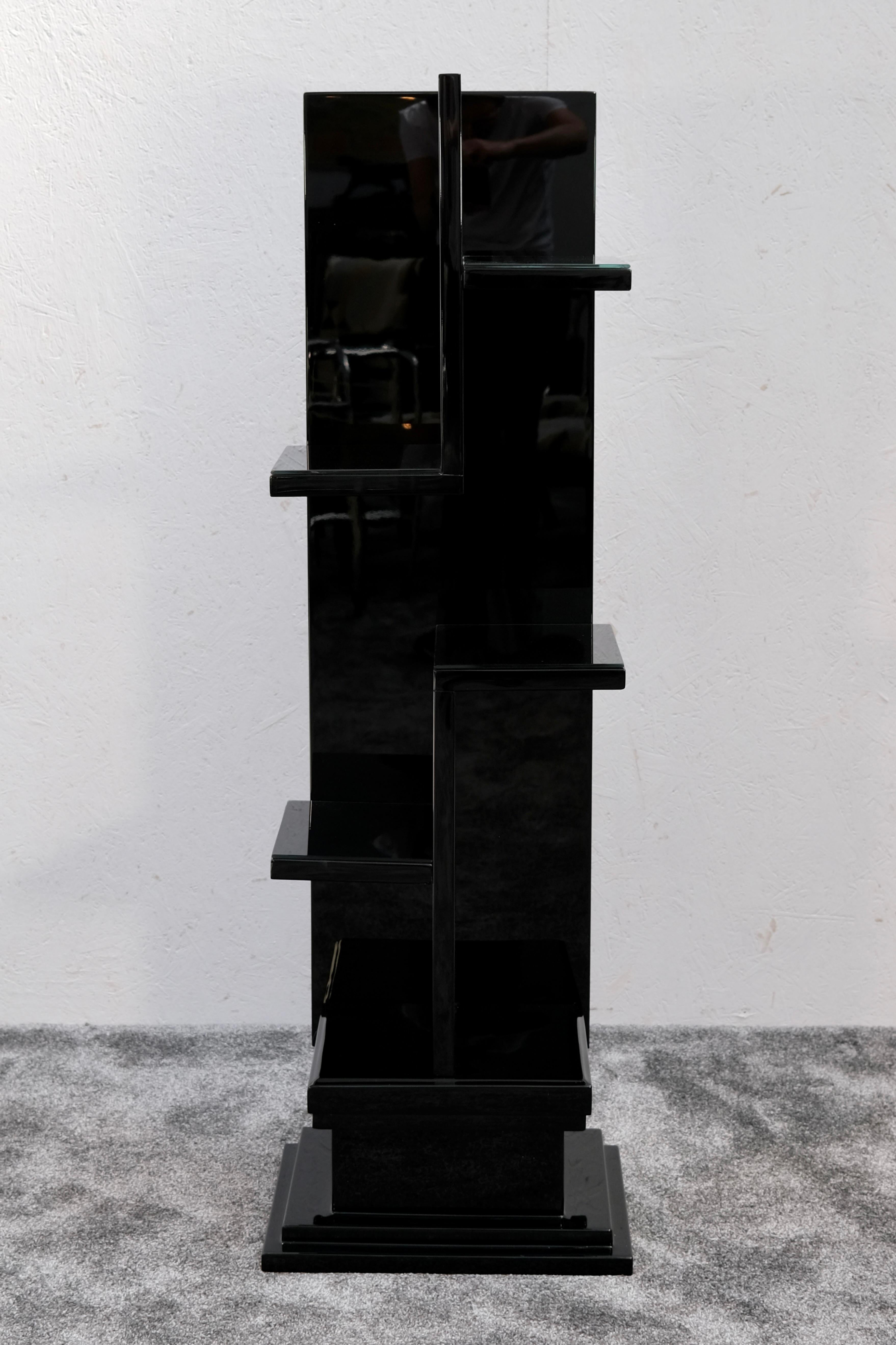 This striking French Art Deco pedestal shelf from the 1930s impresses with its sculptural silhouette and high-gloss black lacquer finish. Designed as a functional accent piece, it features five staggered display platforms arranged along a central
