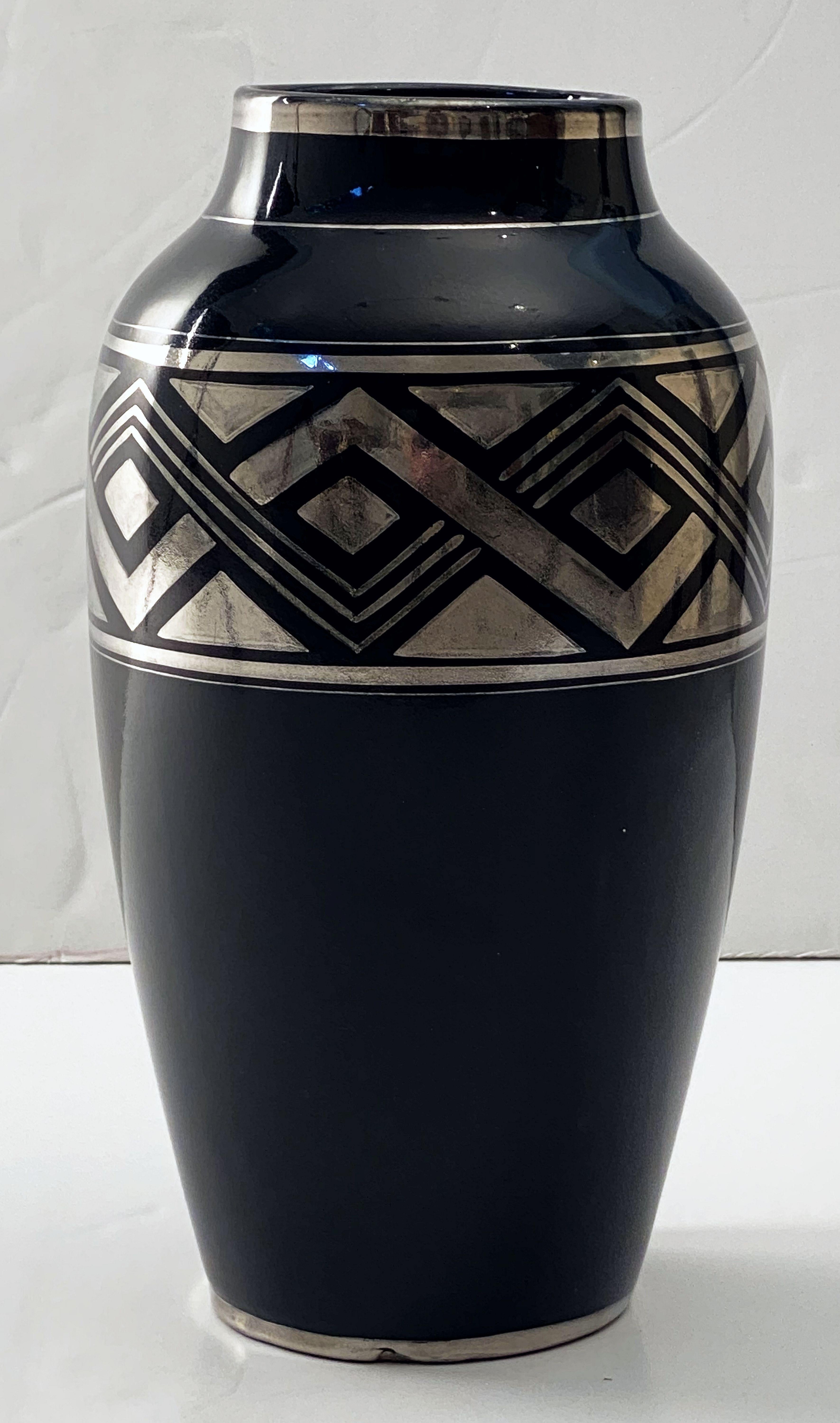 A fine French Art Deco black vase featuring a striking geometric design in silver around the circumference, by the celebrated designers, Odette Berlot and Yvonne Mussier, or ODYV, who were prominent in the Art Deco period.

Two