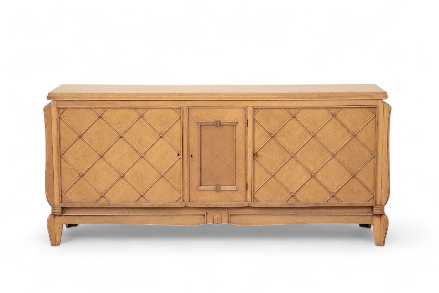 Credenza francese Art Déco con finitura sbiancata e motivi geometrici a croce
2 ante che nascondono un ampio spazio di archiviazione con ripiani su ogni lato, 
1 anta centrale che nasconde un contenitore e un ripiano
Porte con motivo Croisillon
Il