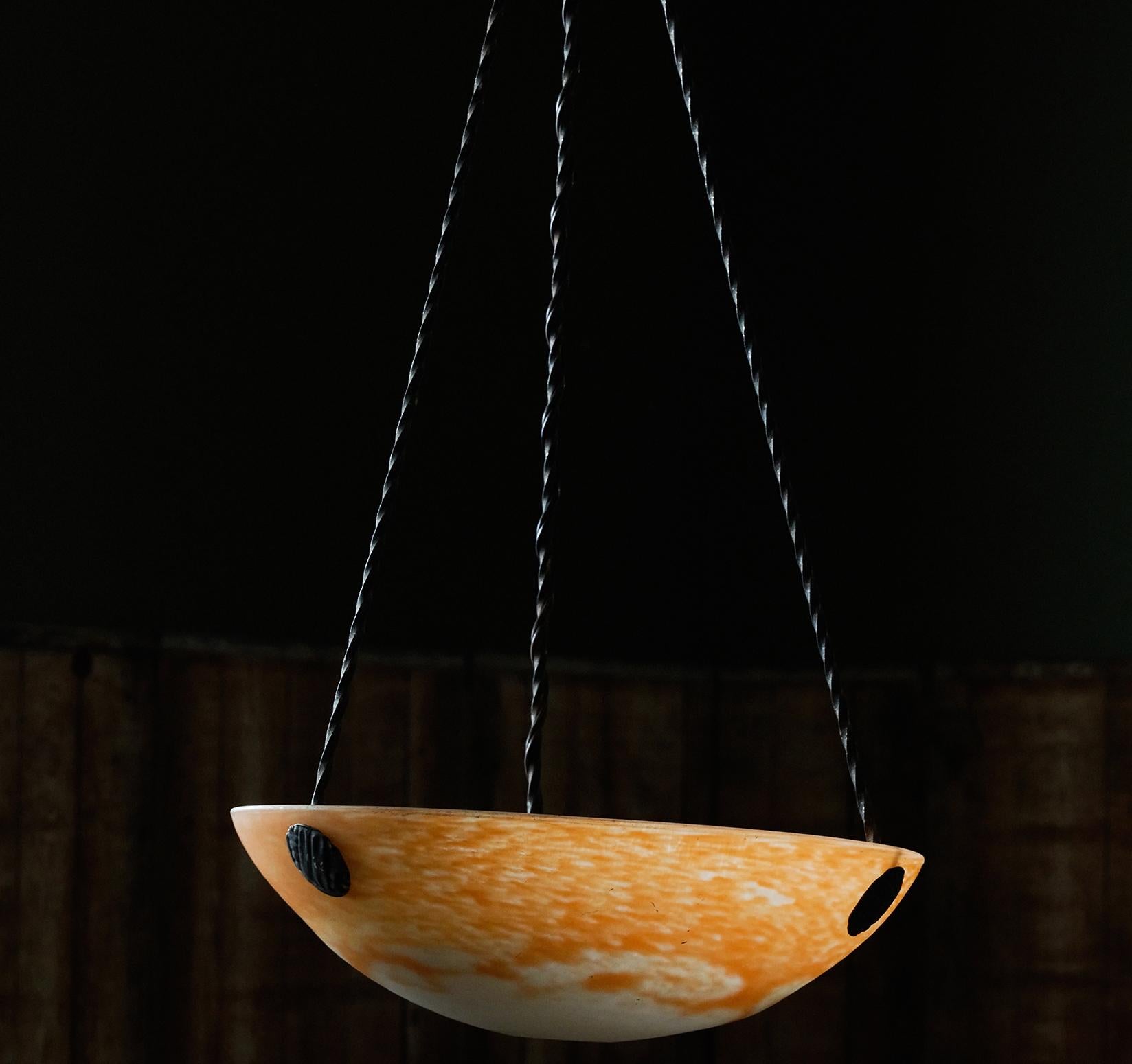 The Art Deco blown glass pendant is blown with double glass with a matte satin appearance. The iron work 