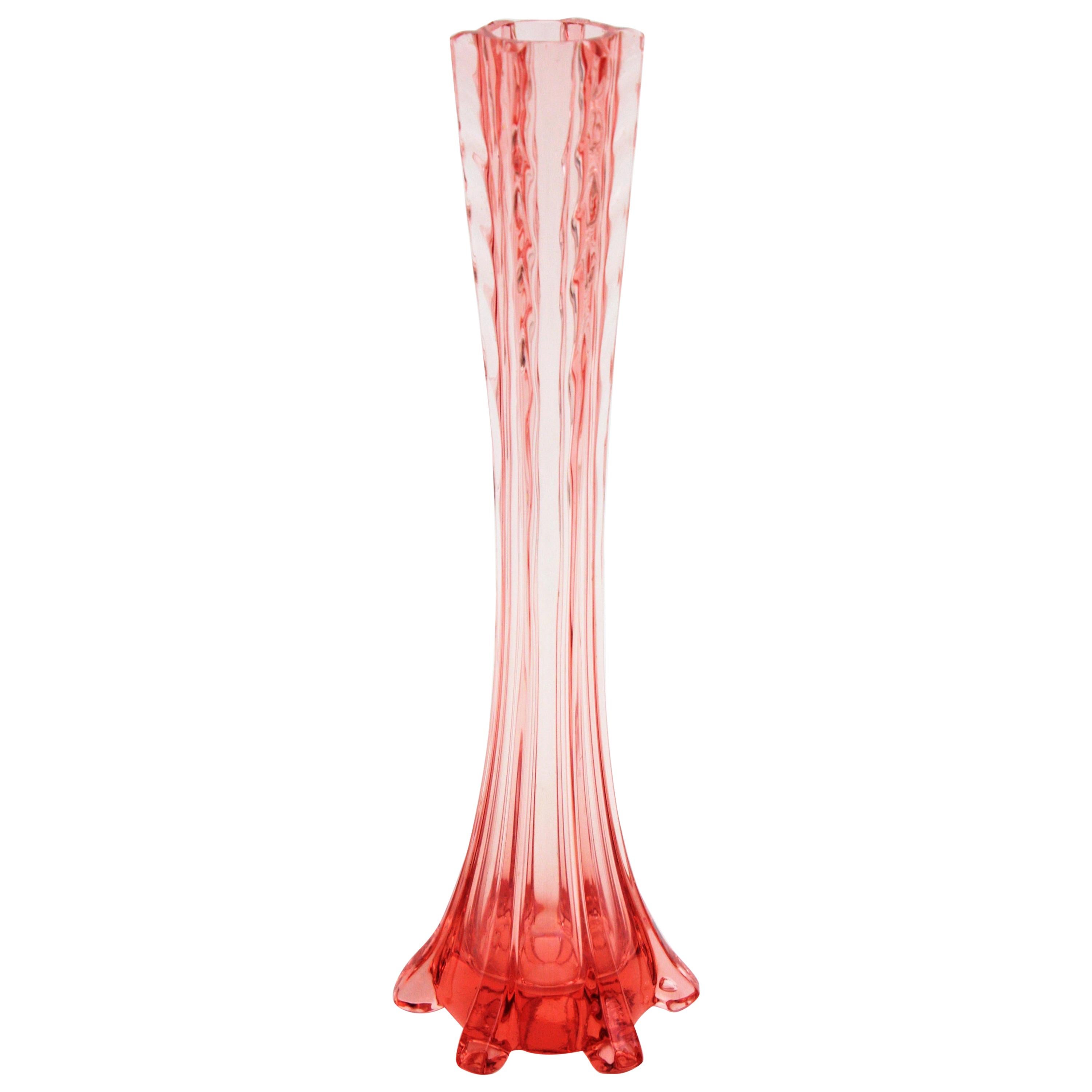 Élégant vase à une fleur de style Baccarat en verre soufflé ambre-rose, France, années 1930.
Ce vase monofloral à long col présente des détails en verre appliqué sur ses côtés et des tourbillons qui décorent le col. Il peut être placé seul ou faire