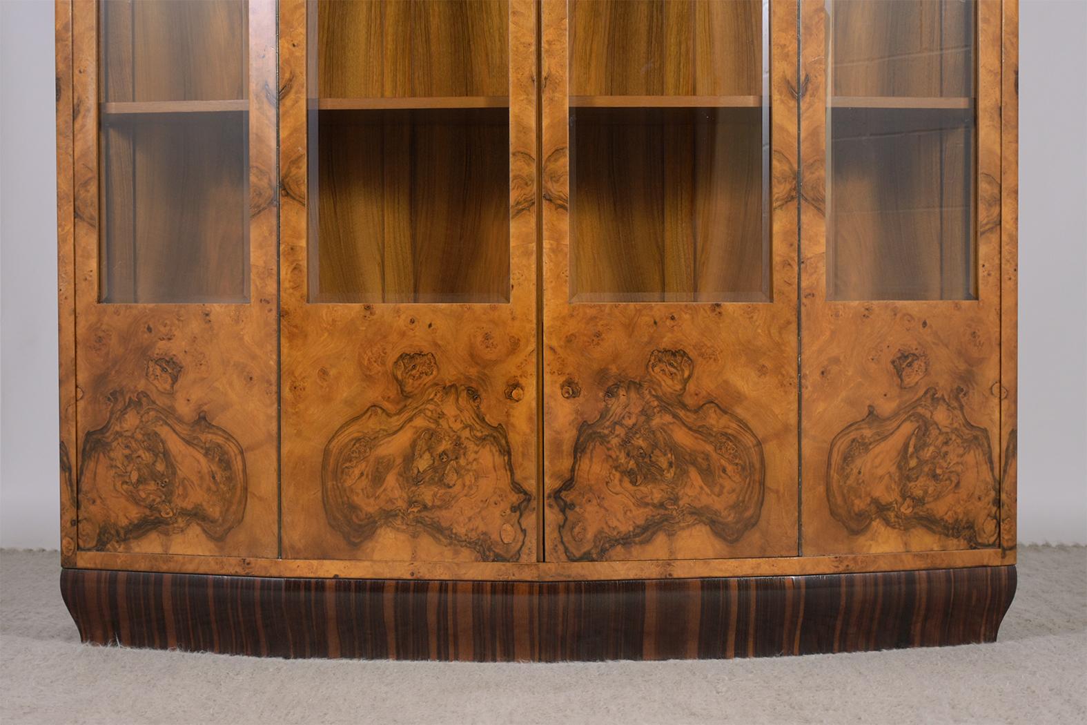 An extraordinary french art-deco bookcase in great condition and fully restored by our expert craftsmen team. This vitrine is beautifully crafted out of solid wood, is completely covered in exotic walnut veneers, and features a light walnut color