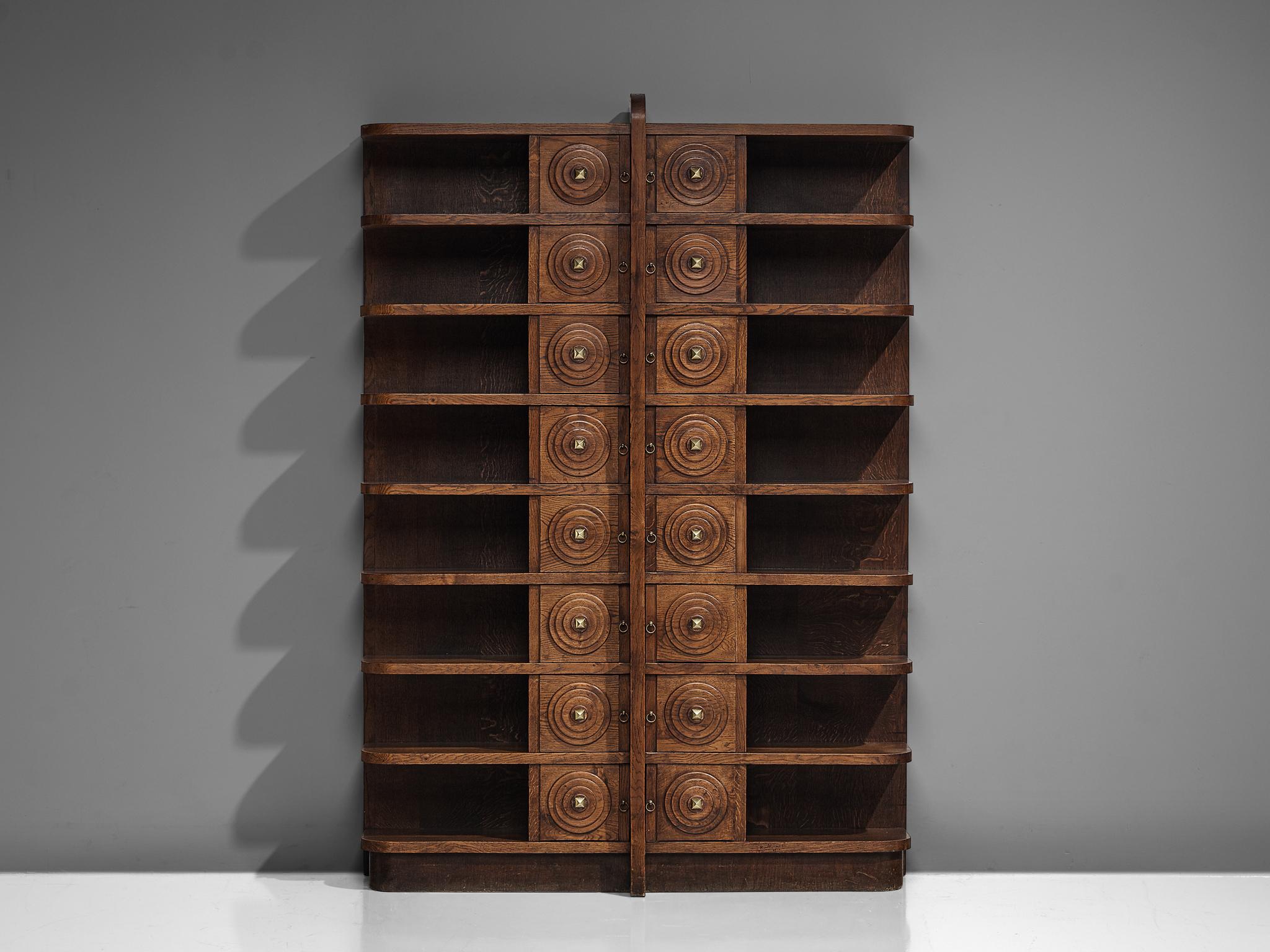 French Art Deco bookcase, patinated oak, brass, Europe, 1930s.

Large Art Deco bookcase in patinated oak in a symmetrical design. The bookcase has eight shelves left and right. The shelves have beautifully rounded edges, which give the bookcase a