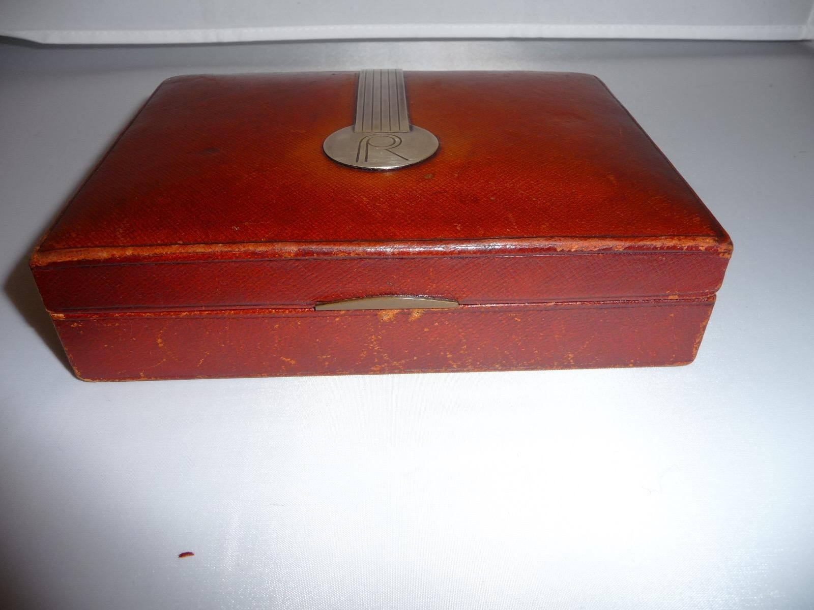 French Art Deco wooden leather box by Jean Emile Puiforcat, Paris. The wooden box is covered with red brown colored leather .The box is signed in the silver application on the lid Jean E.Puiforcat, workshop mark, boar´s head (embossed). It was
