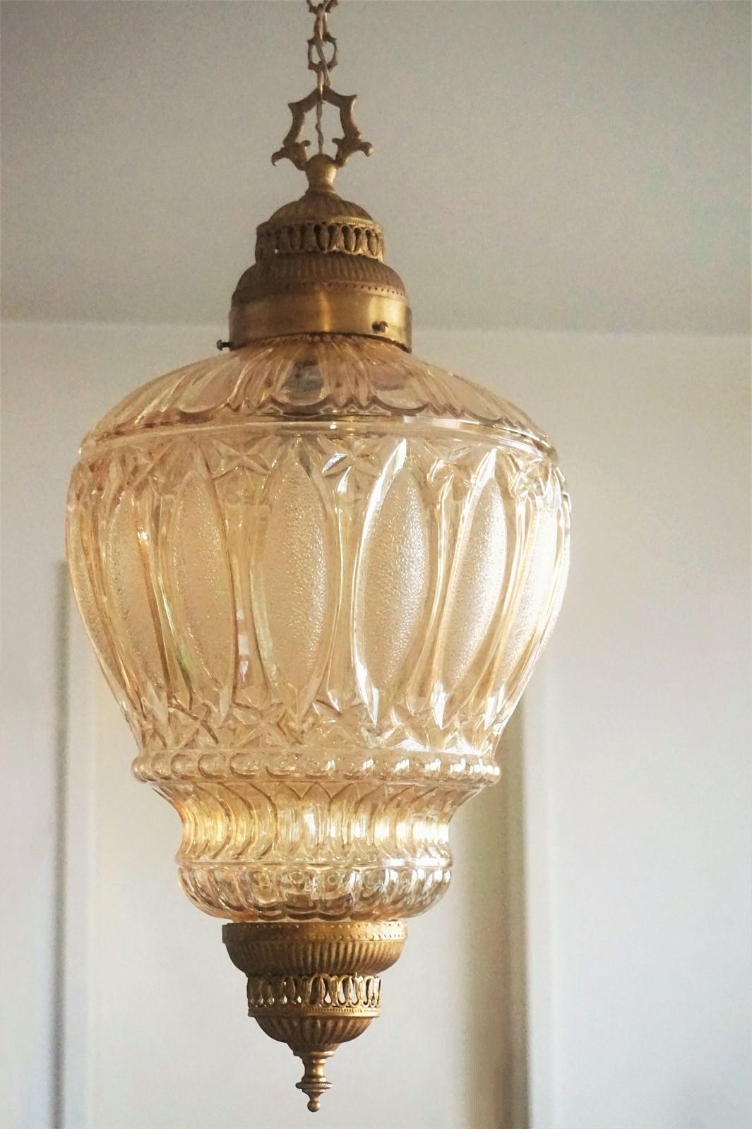 A beautiful Art Deco lantern or pendant with large high relief amber glass shade and brass mounts, France, circa 1930. 
One large light socket for 60w-100w bulb.
Measures:
Total height 44 inch (113 cm), variable height 
Height without chain and