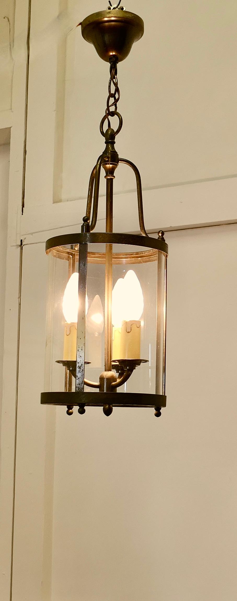 French Art Deco Brass and Glass Lantern Hall Light

A traditional hall lantern, the light has a cylindrical glass shade, and a triple light fitting to the interior it hangs on a short chain from an aged brass ceiling rose
The lantern gives a