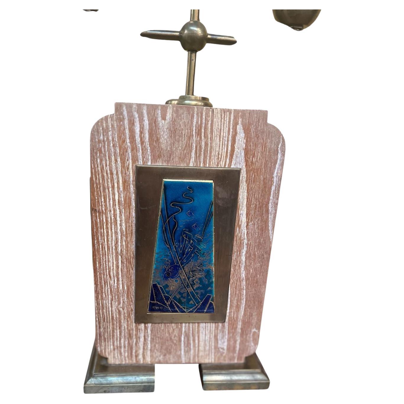 Belle lampe de table Art Déco française. Cette lampe présente une finition en bois lavé blanc et un magnifique laiton patiné avec un étonnant émail sur un accent en laiton qui est signé OCH. Circa 1930's. Dimensions : 10 pouces de large par 4 pouces