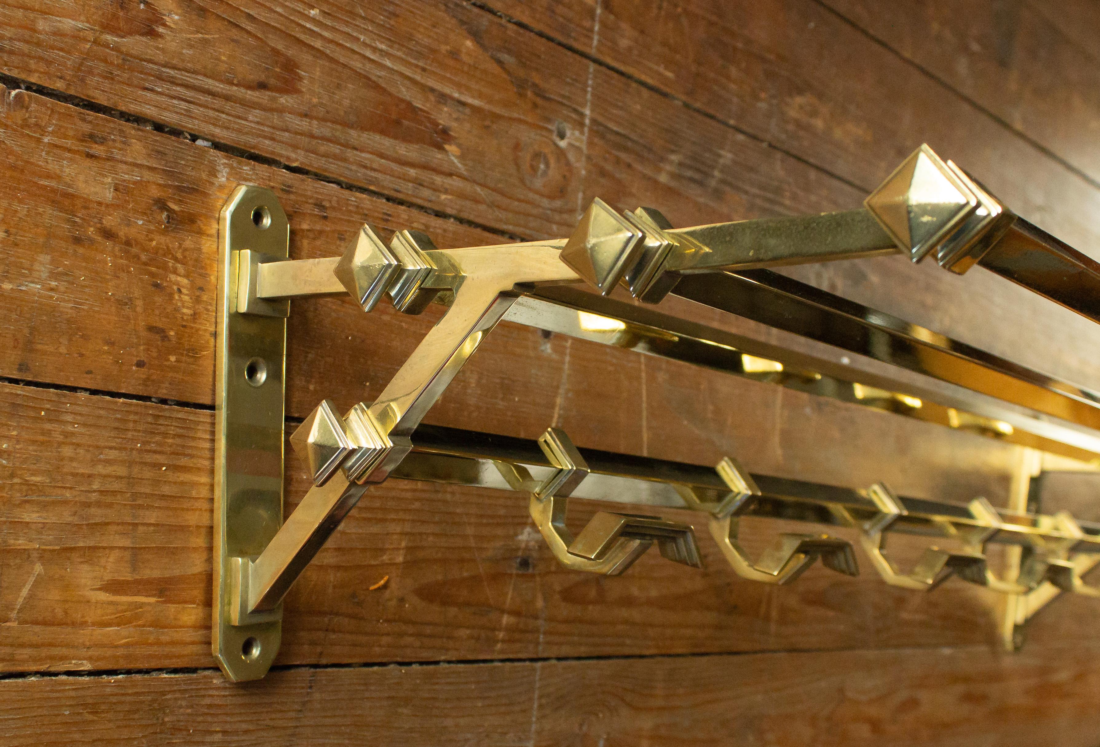 French Art Deco brass coat rack with five coat hooks and upper shelf for hats.