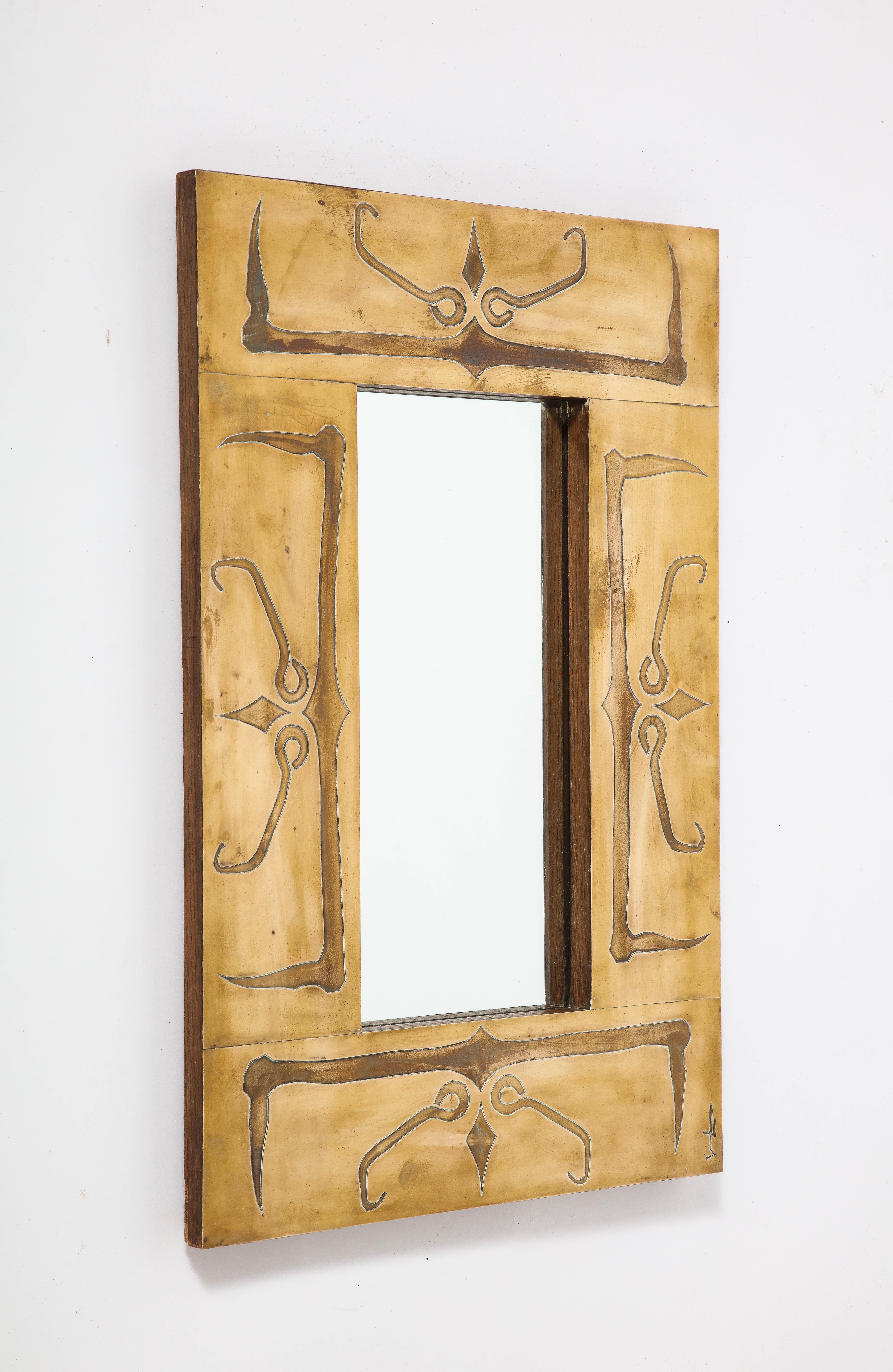 Miroir à encadrement en laiton de style Art déco français, très unique, avec des motifs abstraits gravés.  motif.  Signé dans le coin inférieur droit. 
France, vers 1940
Taille : 24