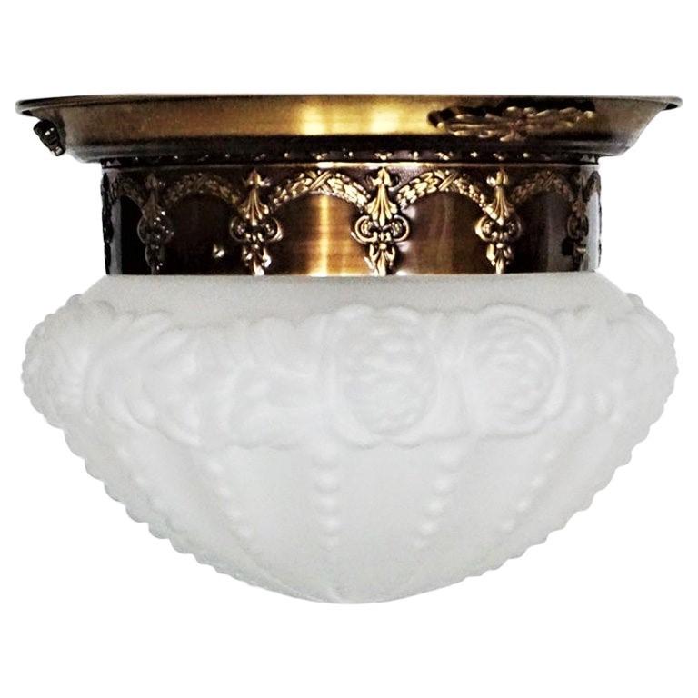 A lovely Art Deco flushmount, France, 1930-1939. Burnished brass base fitted with a frosted high relief glass globe with beautiful detailing.
With one Edison E-27 light socket for a large sized bulb up to 100W.
Two flush mounts