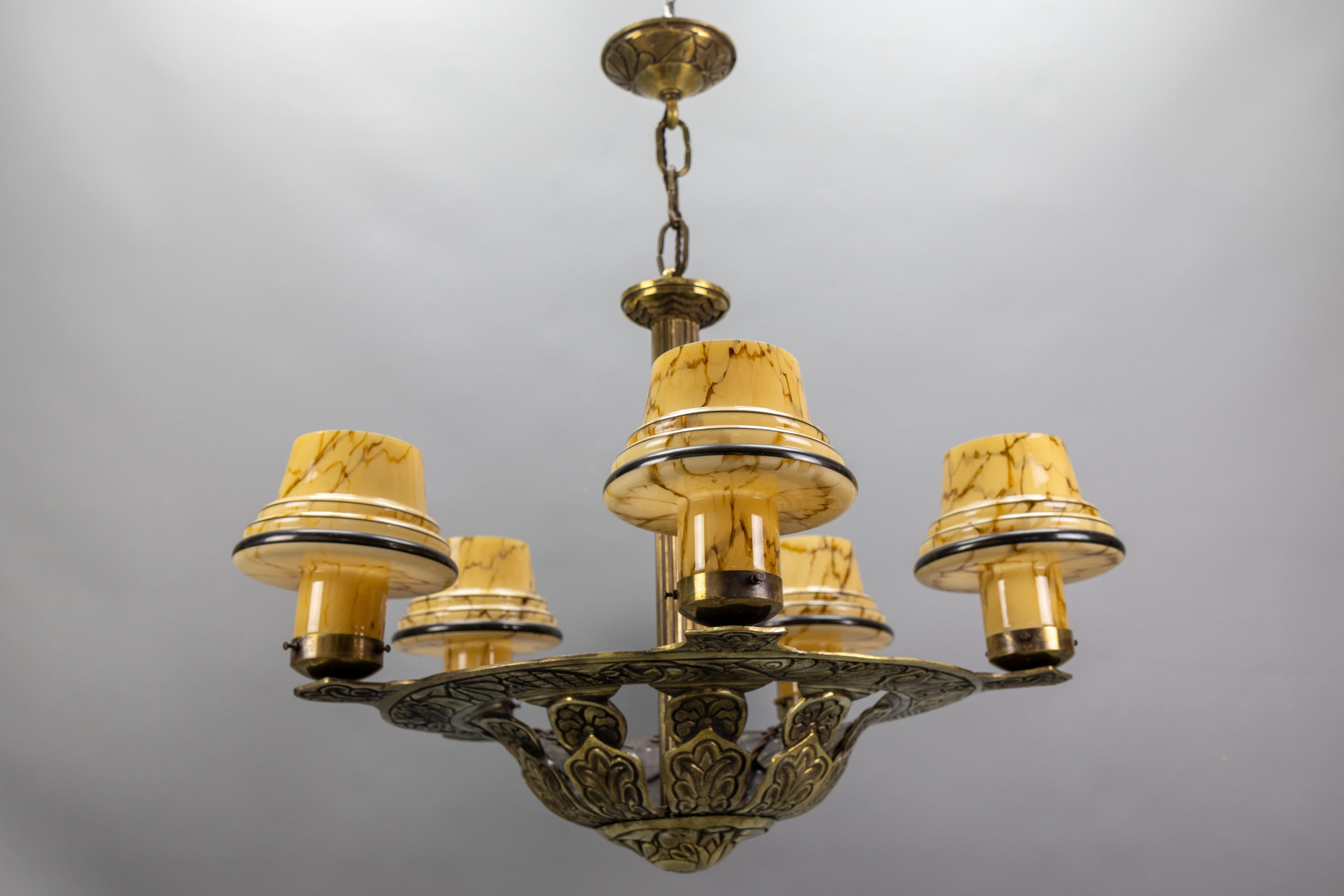 Französischer Art-Déco-Kronleuchter mit fünf Lichtern aus Bronze und marmorierten beigen Pilzglasschirmen, 1930er Jahre

Ein auffälliger französischer Art-Déco-Kronleuchter aus den 1930er Jahren mit fünf wunderschön marmorierten beigen Glasschirmen