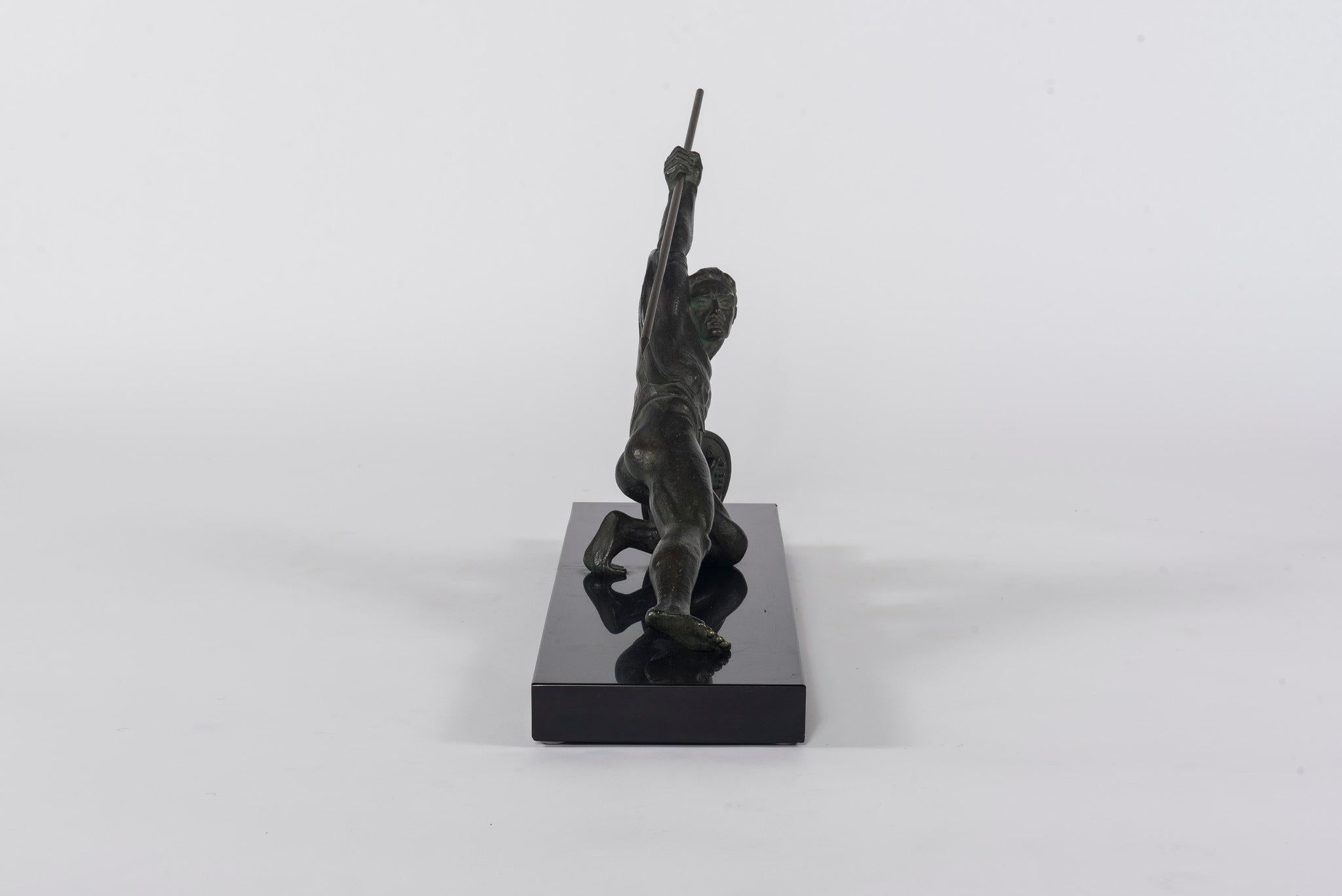 A 1930s French Art Deco bronze Roman warrior figure with spear and shield on black marble base.