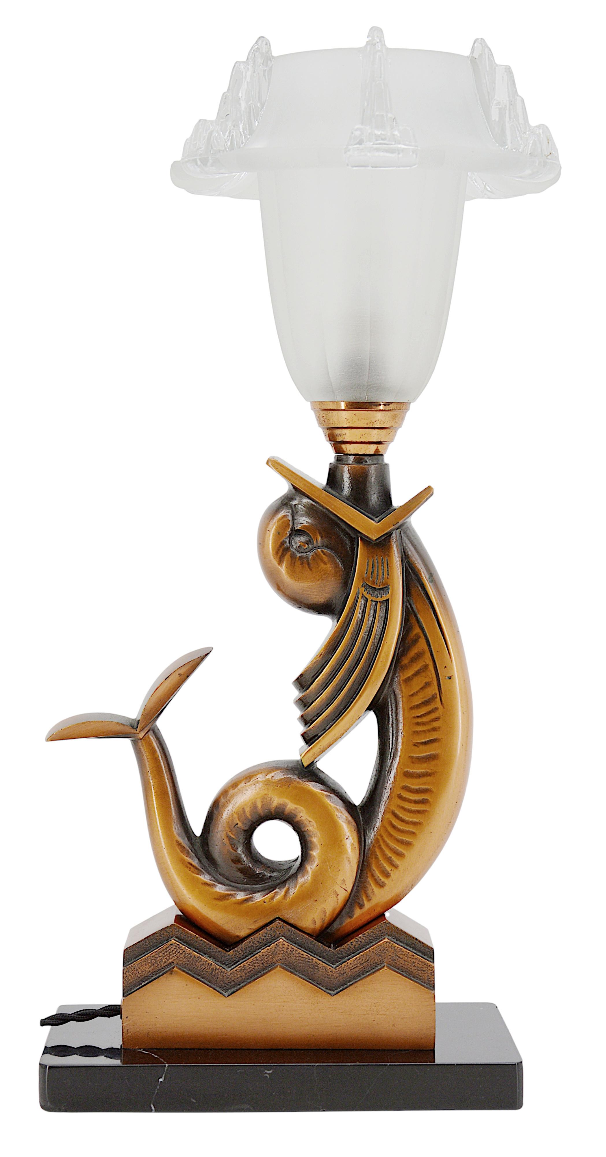 Lampe de table Art déco, France, vers 1930. Spectaculaire poisson stylisé en bronze supportant un abat-jour en verre épais. Abat-jour de Jean Gauthier. Base en marbre. Hauteur : 44,3 cm, largeur : 22 cm, profondeur : 18 cm. Quelques piqûres sur la