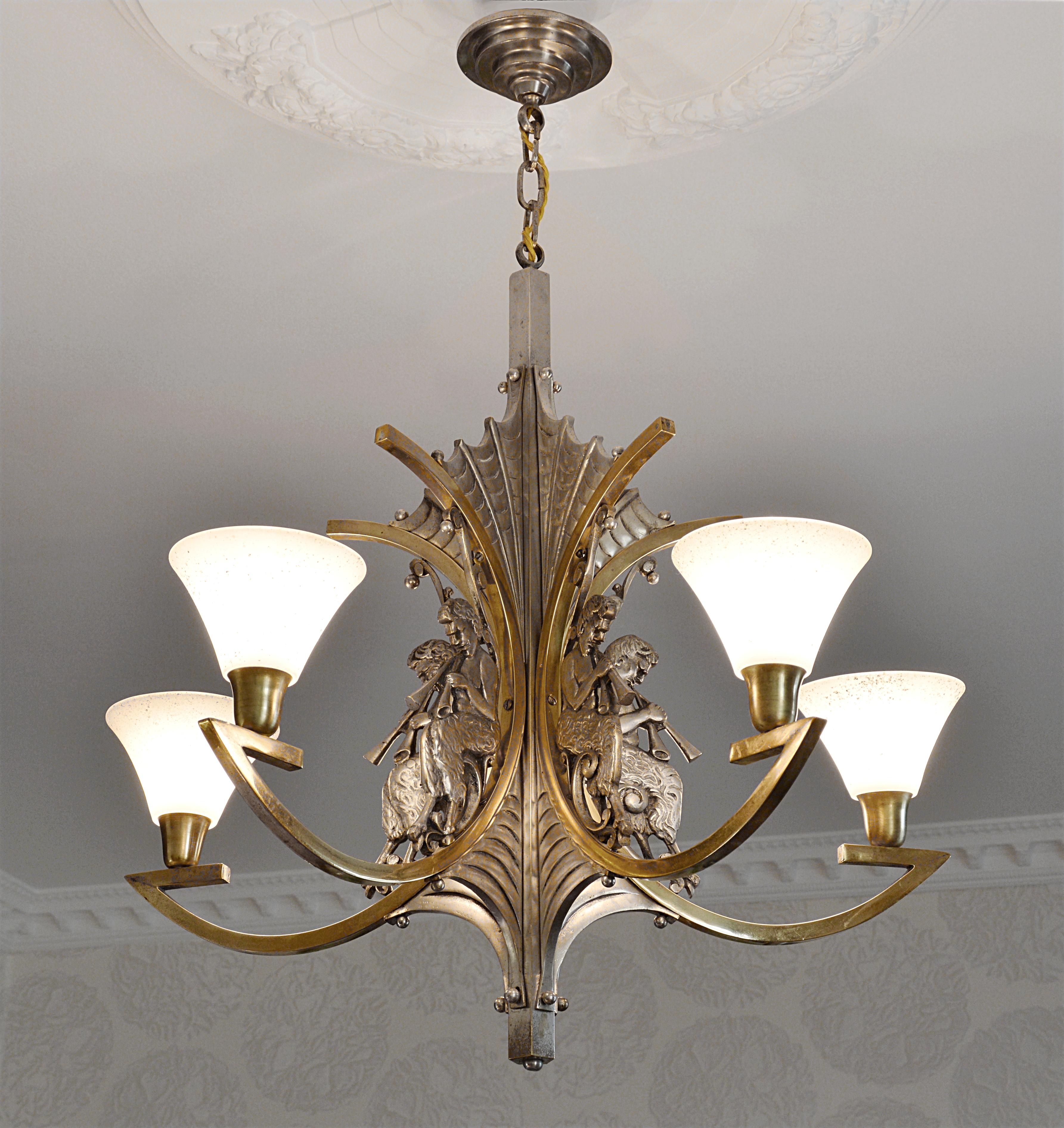 This French Art Deco bronze chandelier was crafted in Paris, France, 1920s. The chandelier features a solid silver-plated bronze fixture adorned with five depictions of the god Pan. Each of the five granite-like glass shades adds to the unique charm