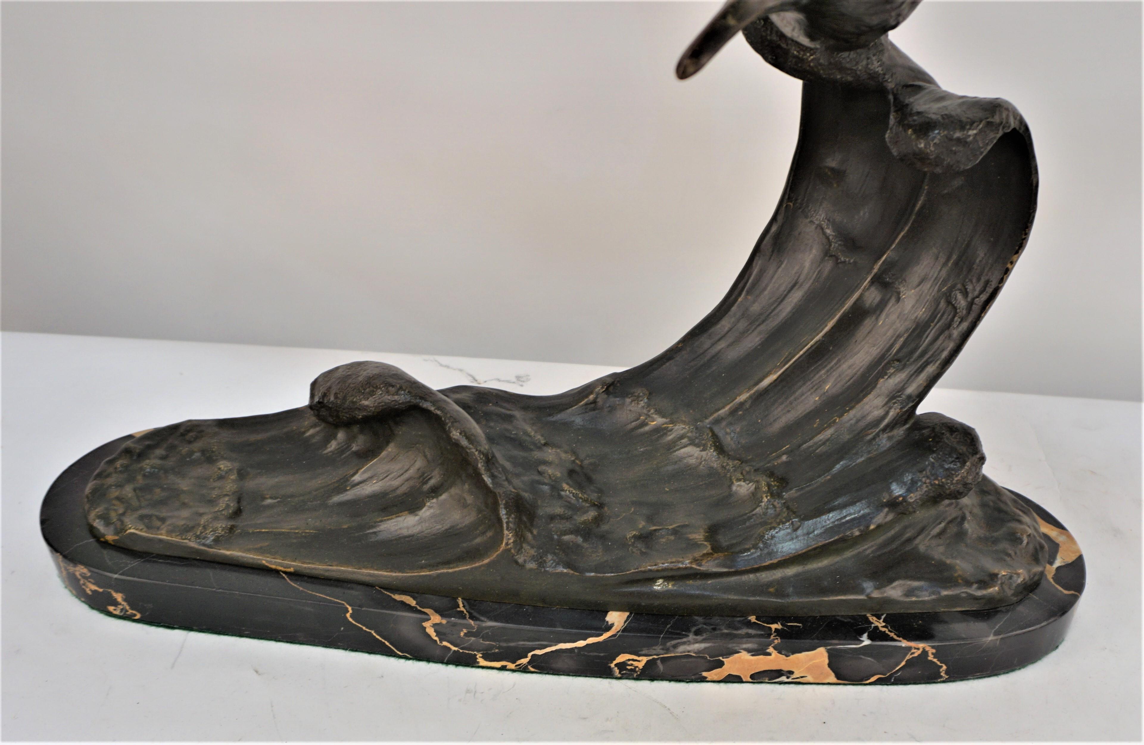 Bronzeskulptur des fliegenden Seagal über der Wasserwelle mit Marmorsockel. 

