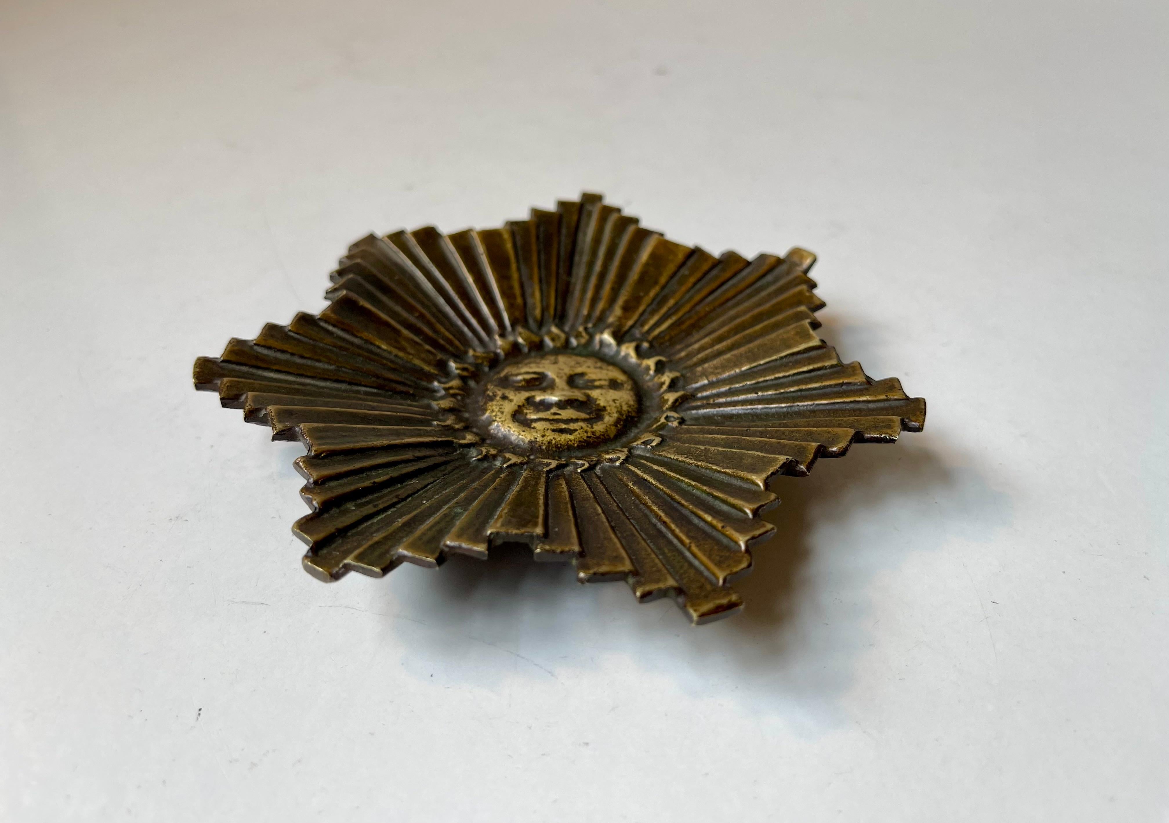 Raro plato o cenicero de bronce macizo que representa un disco solar de Helios -sol abrasador- au Soleil d'or. Se fabricó en Francia hacia 1920-40. No tiene marcas. Presenta una rica y profunda pátina natural y está sin pulir. Medidas: Diámetro: 12