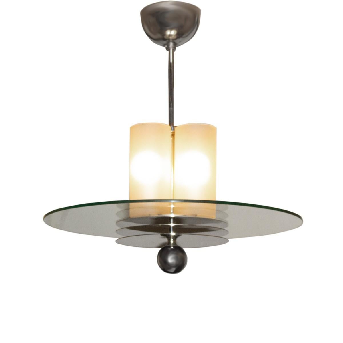 An Art Deco period pendant light fixture. Features a center round glass piece suspended from a burnished nickel stem with matching ceiling canopy. Complemented by a lighted frosted glass shade and a burnished nickel ball. France, circa