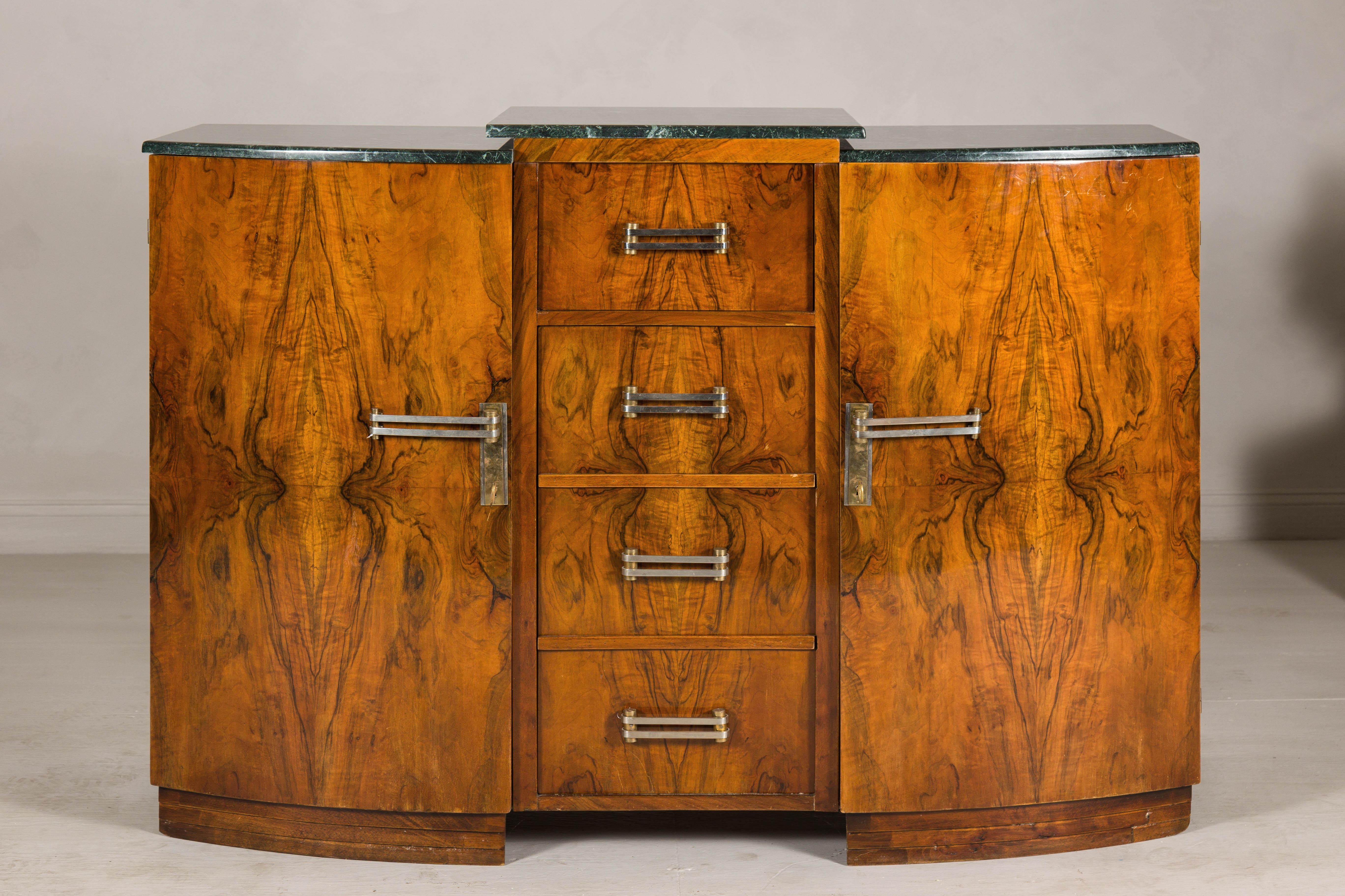 This French Art Deco buffet is a stunning example of early 20th-century craftsmanship, blending elegant design with practical features. Its walnut burl veneer showcases intricate grain patterns, while the rich, dark green marble top—composed of