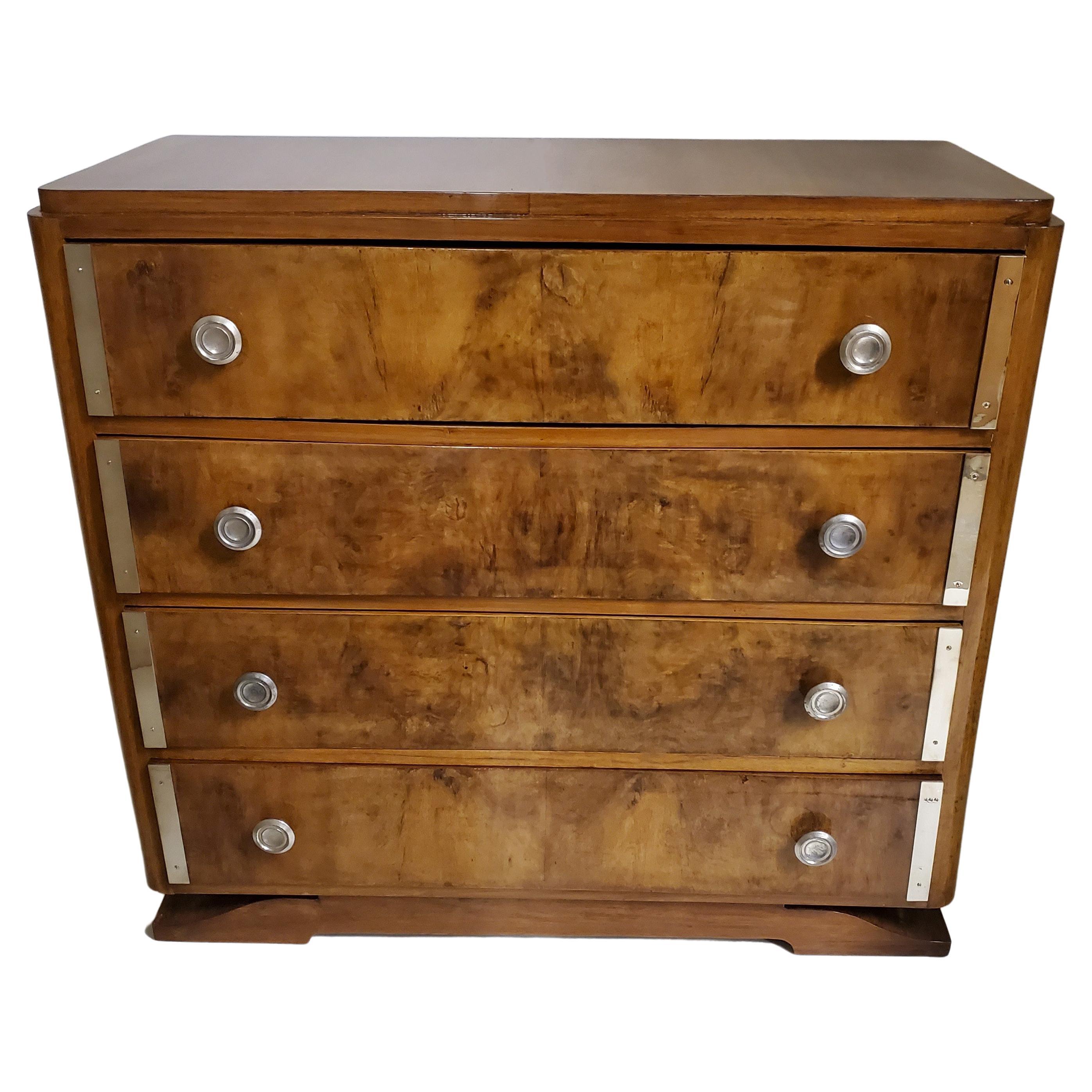 A luxurious, vintage four drawer French Art Deco dresser, chest of drawers in burl walnut featuring a lively grain pattern with a rich, warm appearance. The burl wood provides a unique and eye-catching texture that is both sumptuous and rustic at