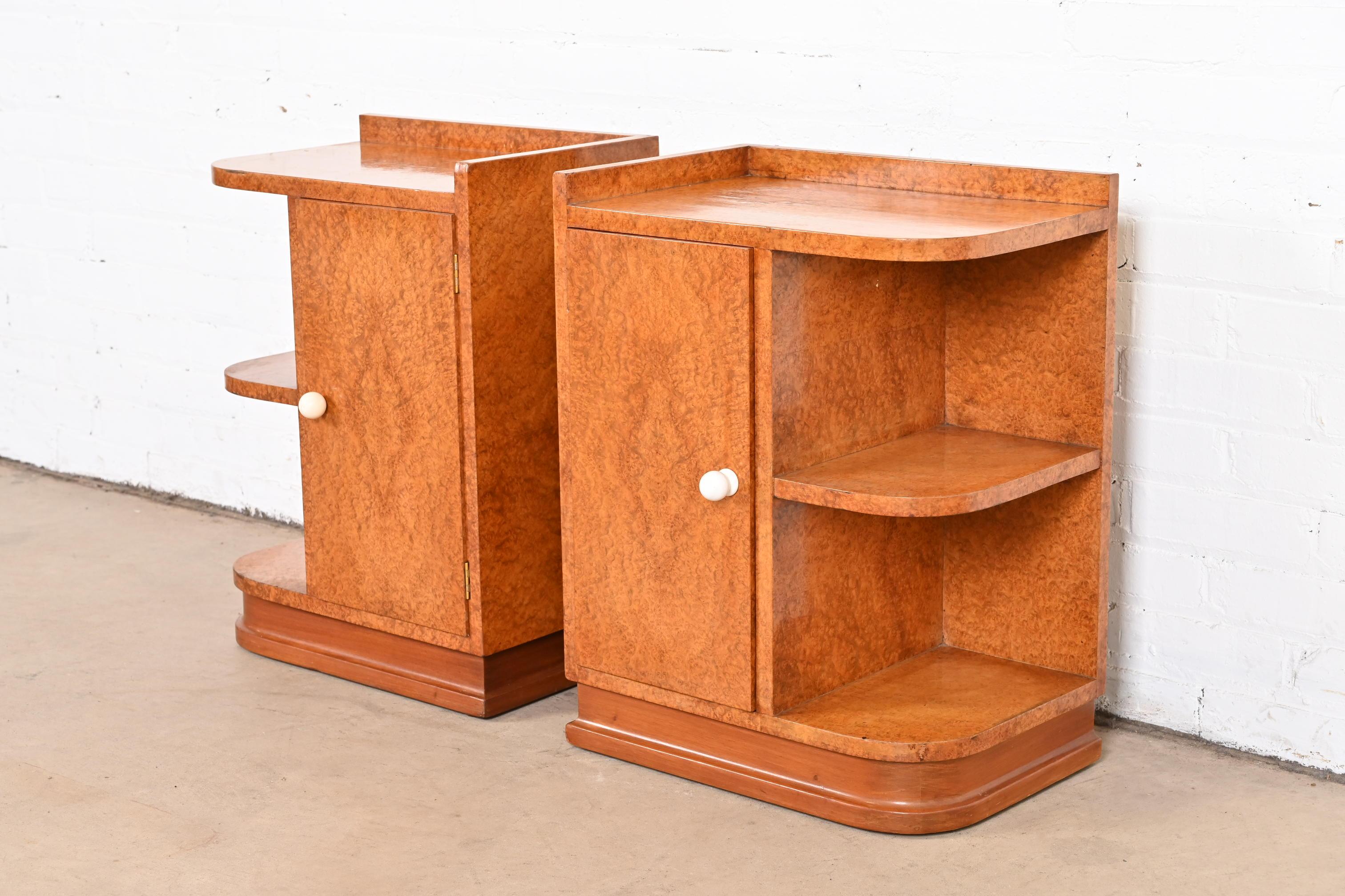 A gorgeous pair of French Art Deco nightstands or end tables

In the manner of Maison Dominique

France, circa 1930s

Stunning burl wood, with walnut plinth base.

Measures: 18