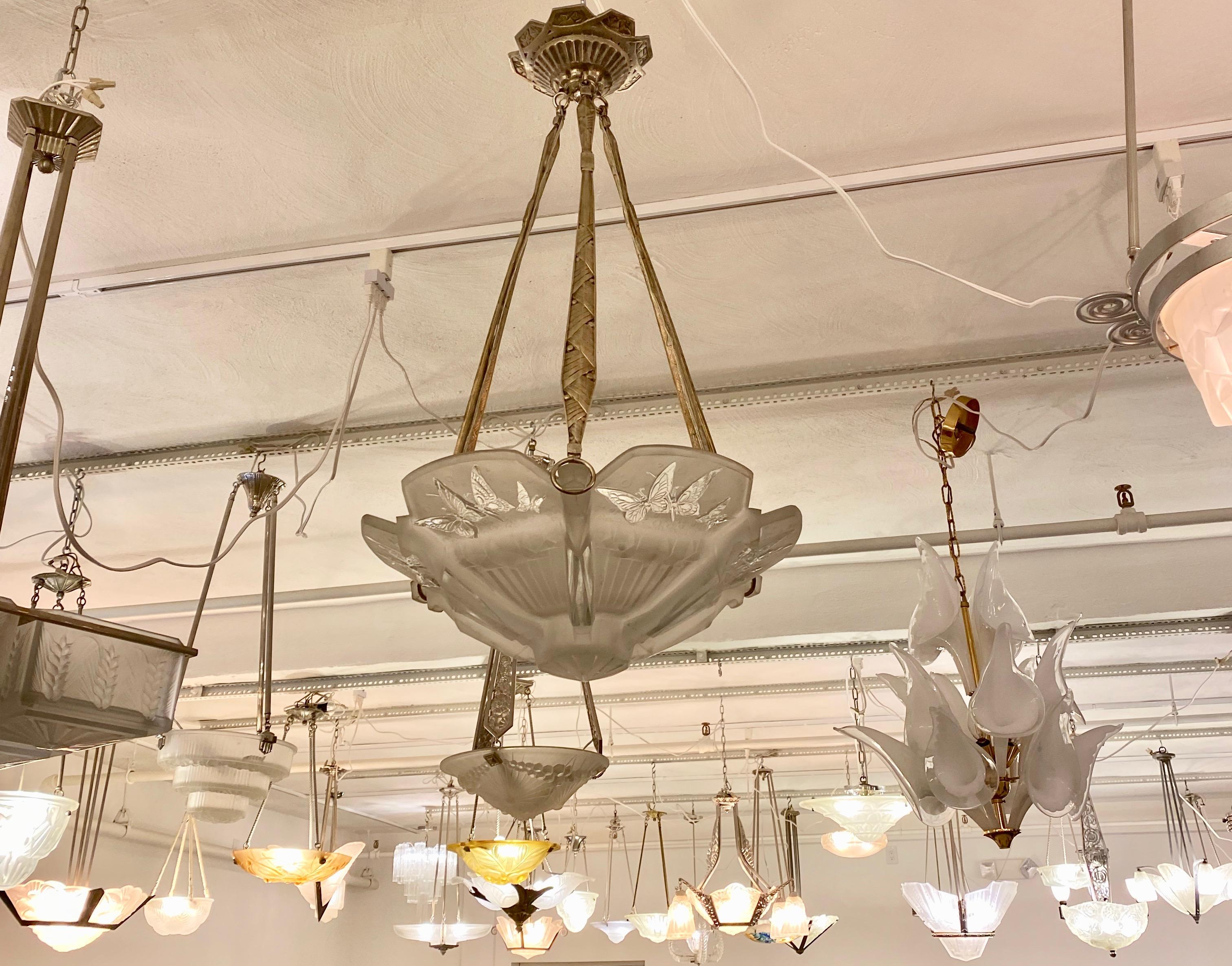 French Art Deco pendant chandelier signed by Muller Freres Luneville. Center glass bowl having geometric and butterfly motif throughout. Held by a matching nickel deco design frame with geometric motif that leads all the way to the ceiling plate.
