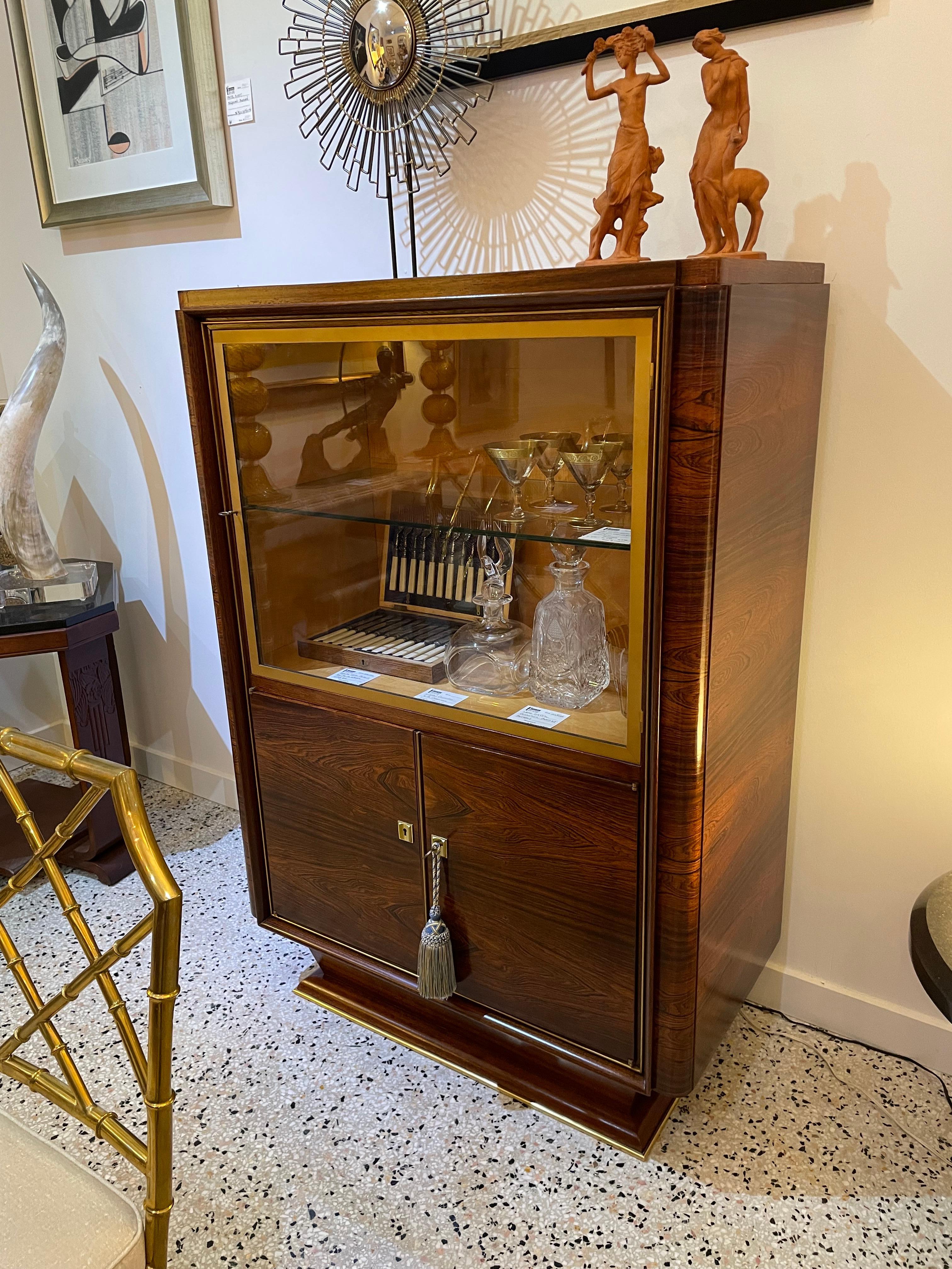 Questo elegante e raffinato mobile francese in stile art déco risale agli anni '30-'40 e riprende lo stile dei pezzi creati da Christian Krass. Il pezzo è realizzato in legno di palissandro, vetro e bronzo ed è stato restaurato professionalmente.