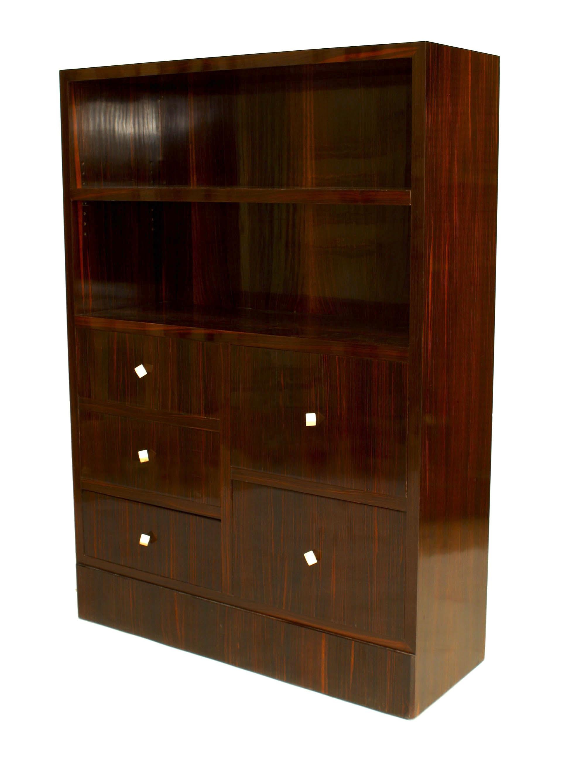 French Art Deco calamander wood bookcase with two open bookshelves above a set of three small and two large drawers finished with cubical bone pulls.


The decorating firm of Dominique was established in l922 at 104 Faubourg Saint-Honore, Paris.