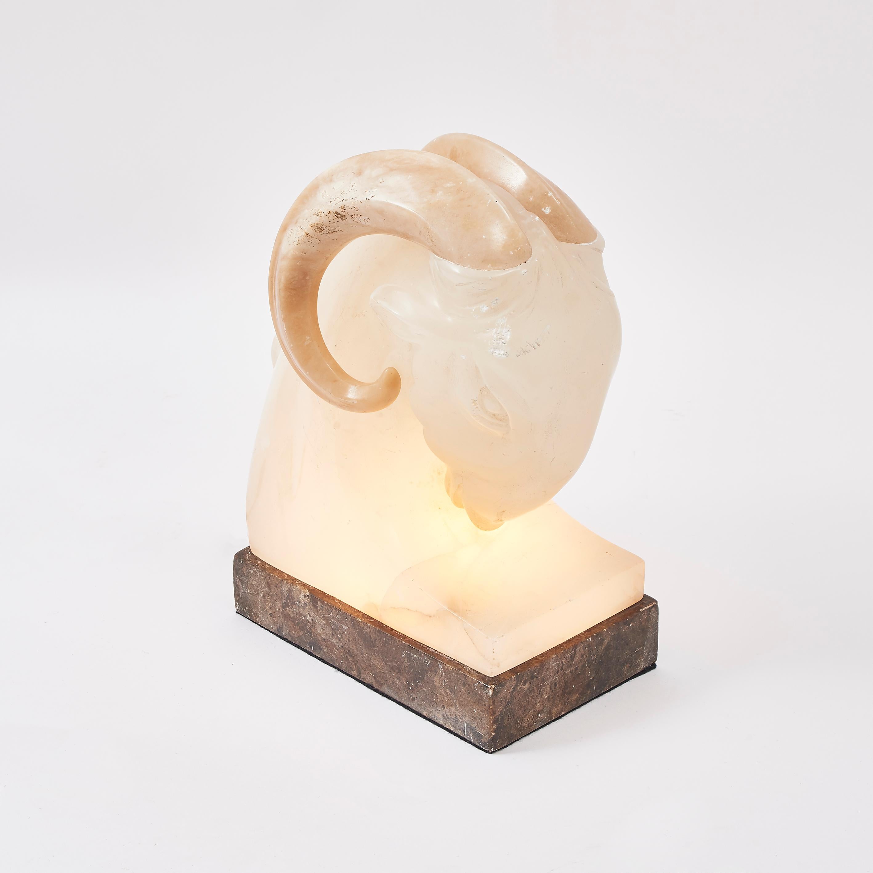 An Art Deco alabaster ram's head, wired as a light, France, circa 1930. An etherial lighting piece, or indeed a sculpture. The downward facing head is formed of a light alabaster with the rams features softly carved into place, the horns in a