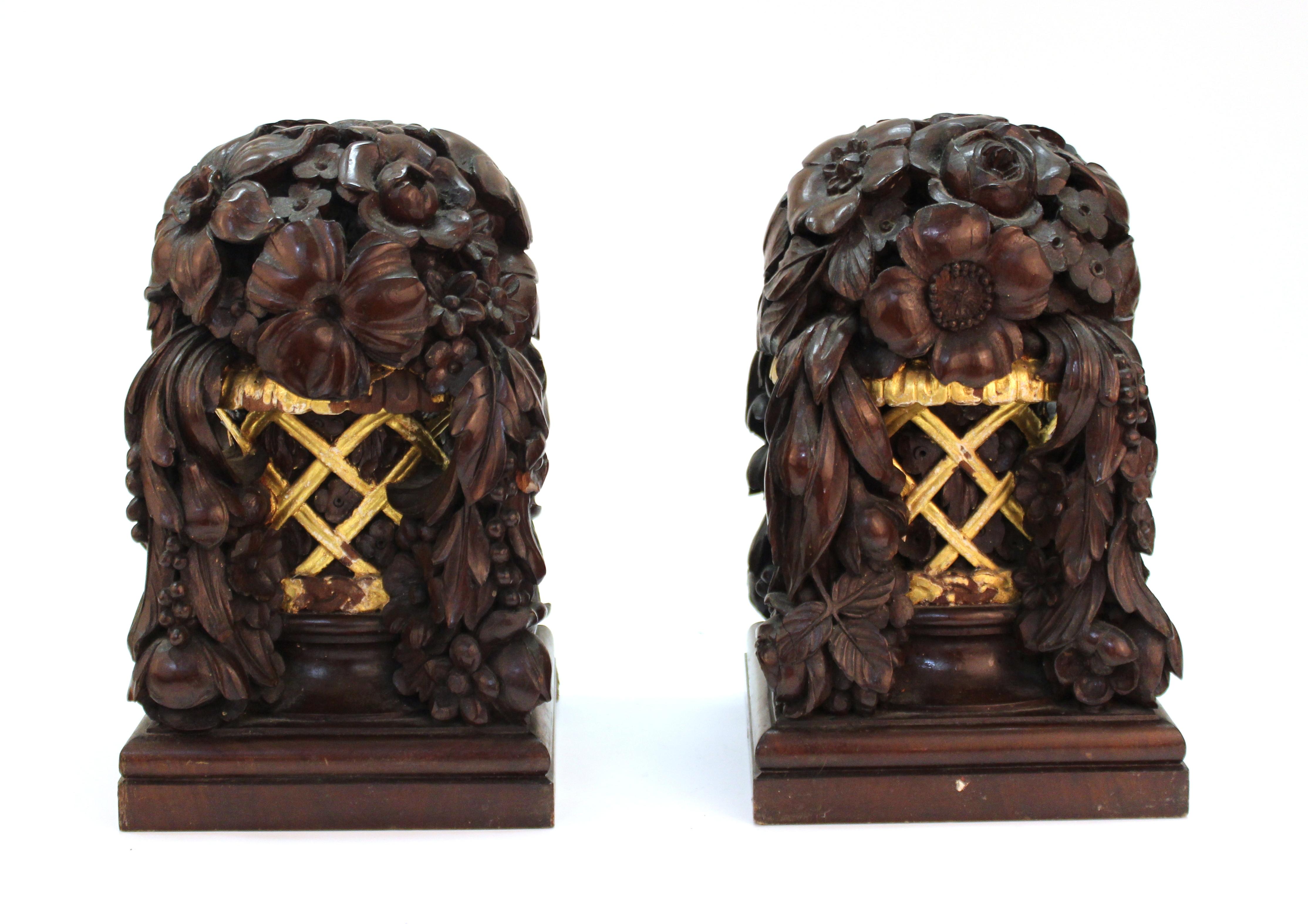 French Art Deco carved and partially gilt wood decorative floral baskets with cascading fruit garlands attributed to French designers Louis Sue and Andre Mare. The pair was likely designed as decorative finials or architectural elements for an Art