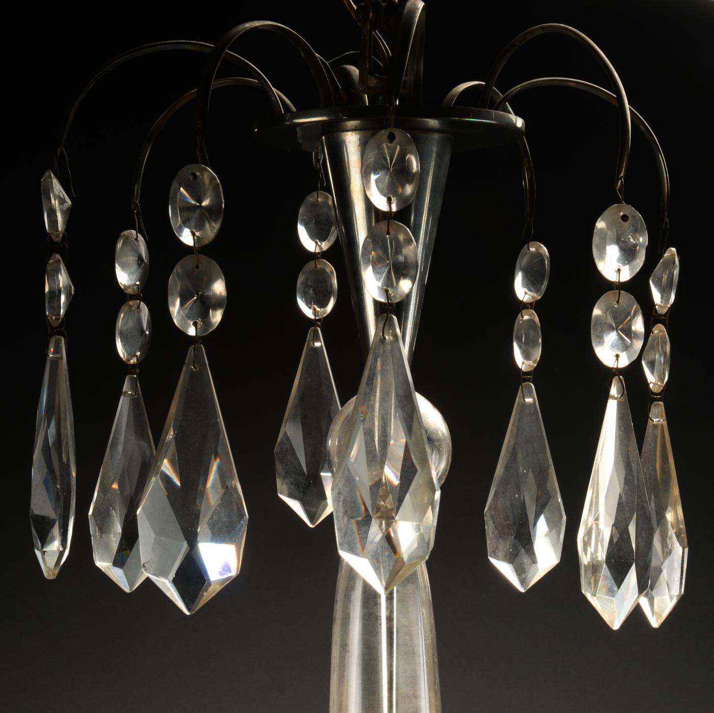 Beautiful French Art Deco chandelier from the 1920s with four light arms with shades of frosted glass with beam grinders, stem and prisms of glass, frame and top of nickel-plated metal.
Dimensions: H 94, Ø 40 cm.
Original condition with four