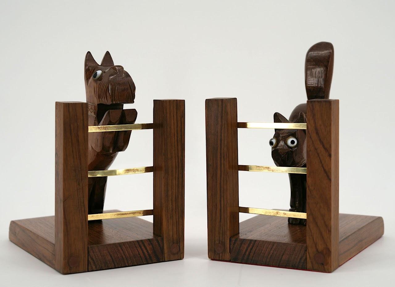 These charming French Art Deco bookends, dating from the 1920s, feature a noble combination of woods and brass, showcasing the elegant craftsmanship of the era. The cat and dog figures are enhanced with striking glass eyes, adding an expressive and