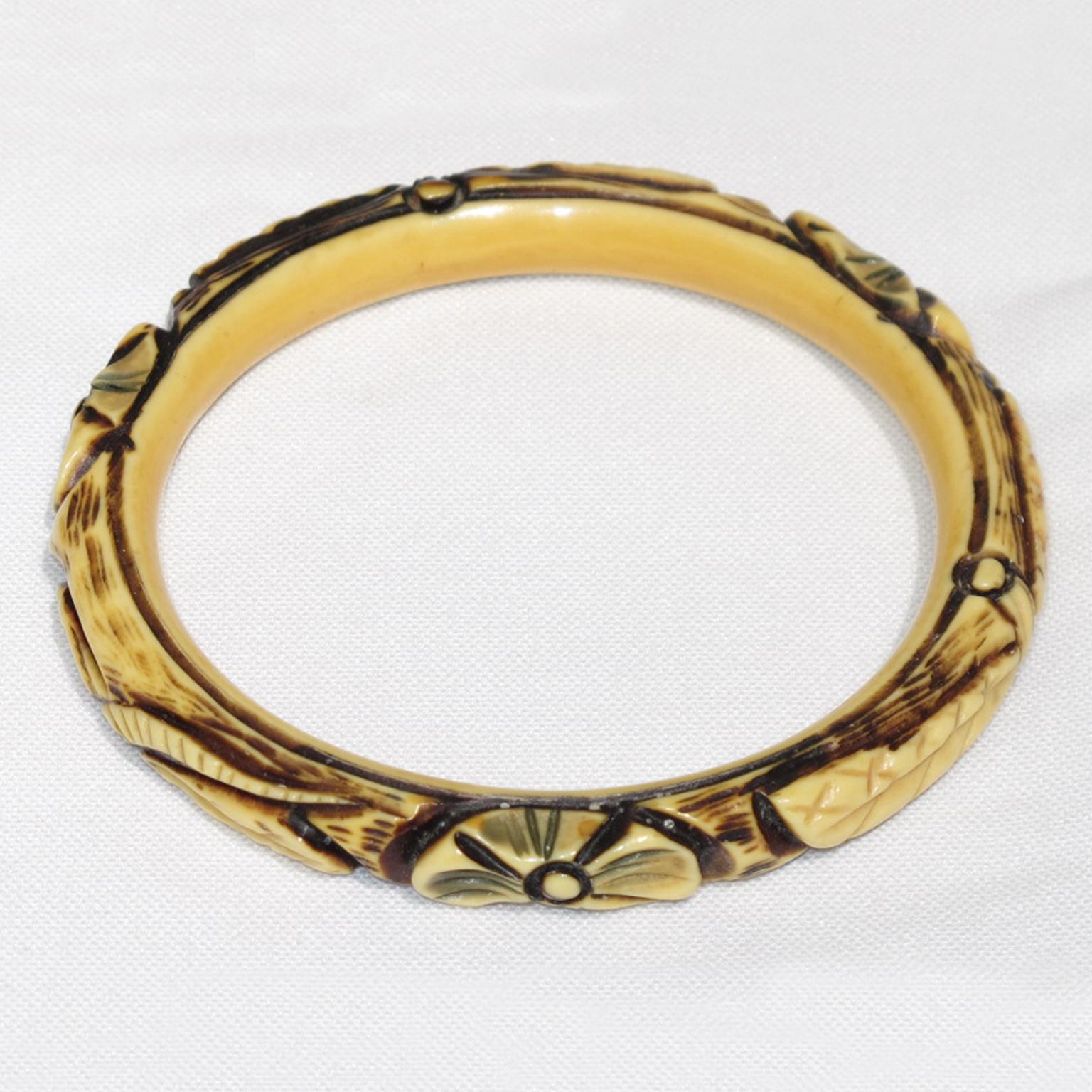 This gorgeous 1925 Art Deco celluloid bracelet bangle features a floral and geometric intricate shape, with three motifs all around the bracelet, complemented with deep carved, painted, and stained designs with a lovely range of off-white, black,