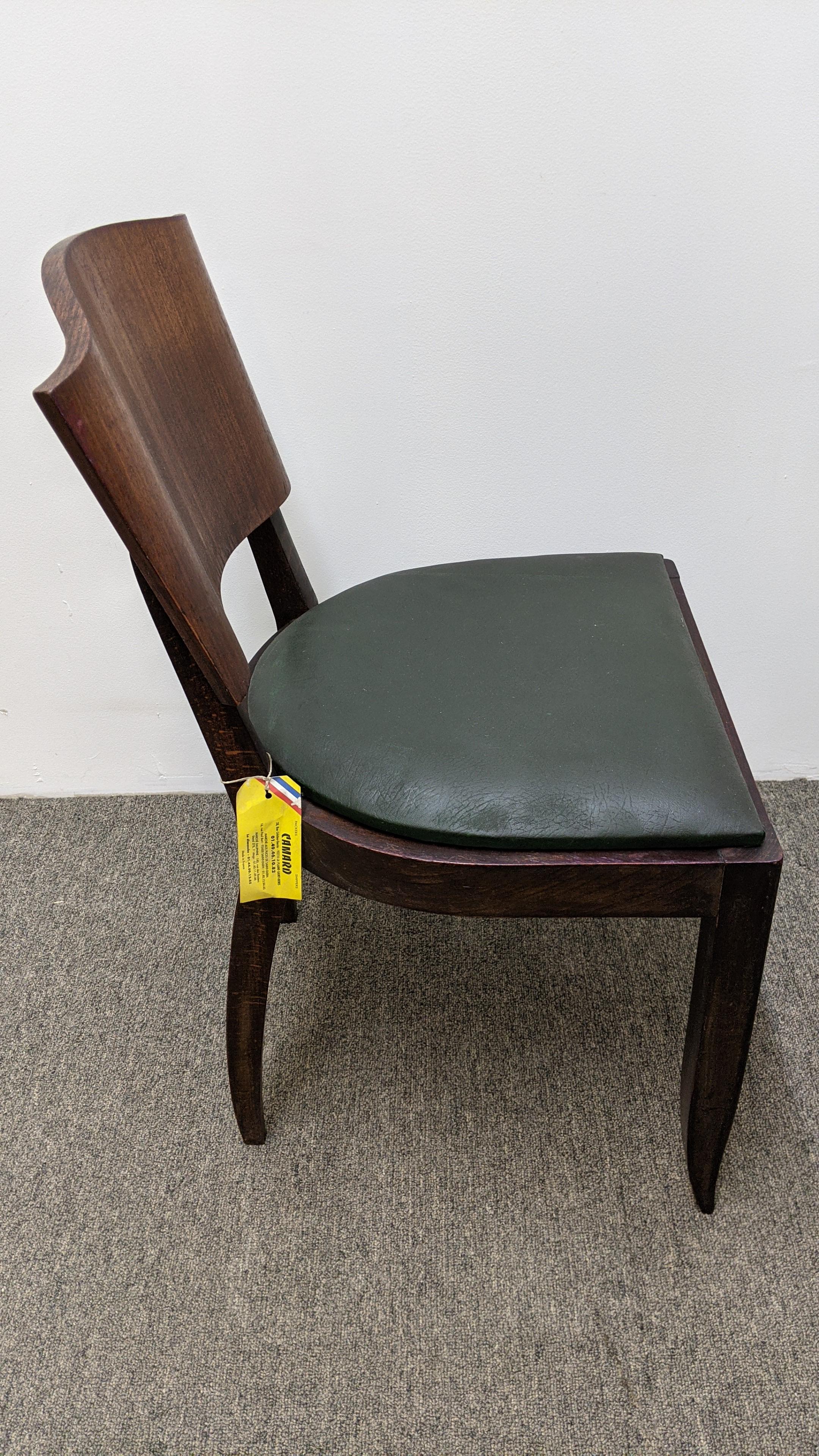 These French Art Deco chairs are a set of six from 1930s. They are part of a complete dining room set. The chairs feature saber front legs and splay rear legs with a unique wave shape backrest design in Brazilian mahogany. They need to be refinished