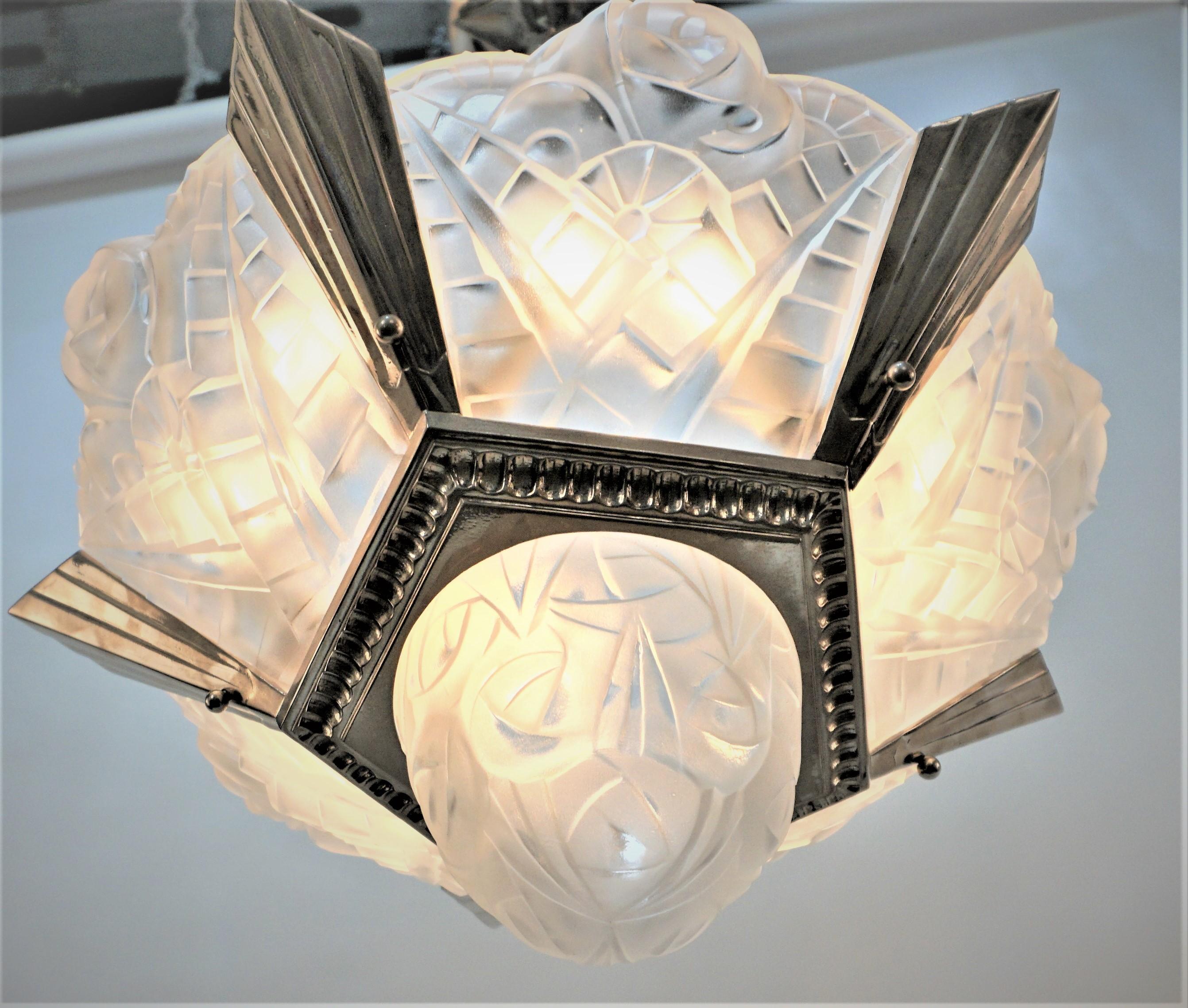 Lustre art déco à onze lumières en verre clair givré à motif de flore géométrique avec nickel sur cadre en bronze.