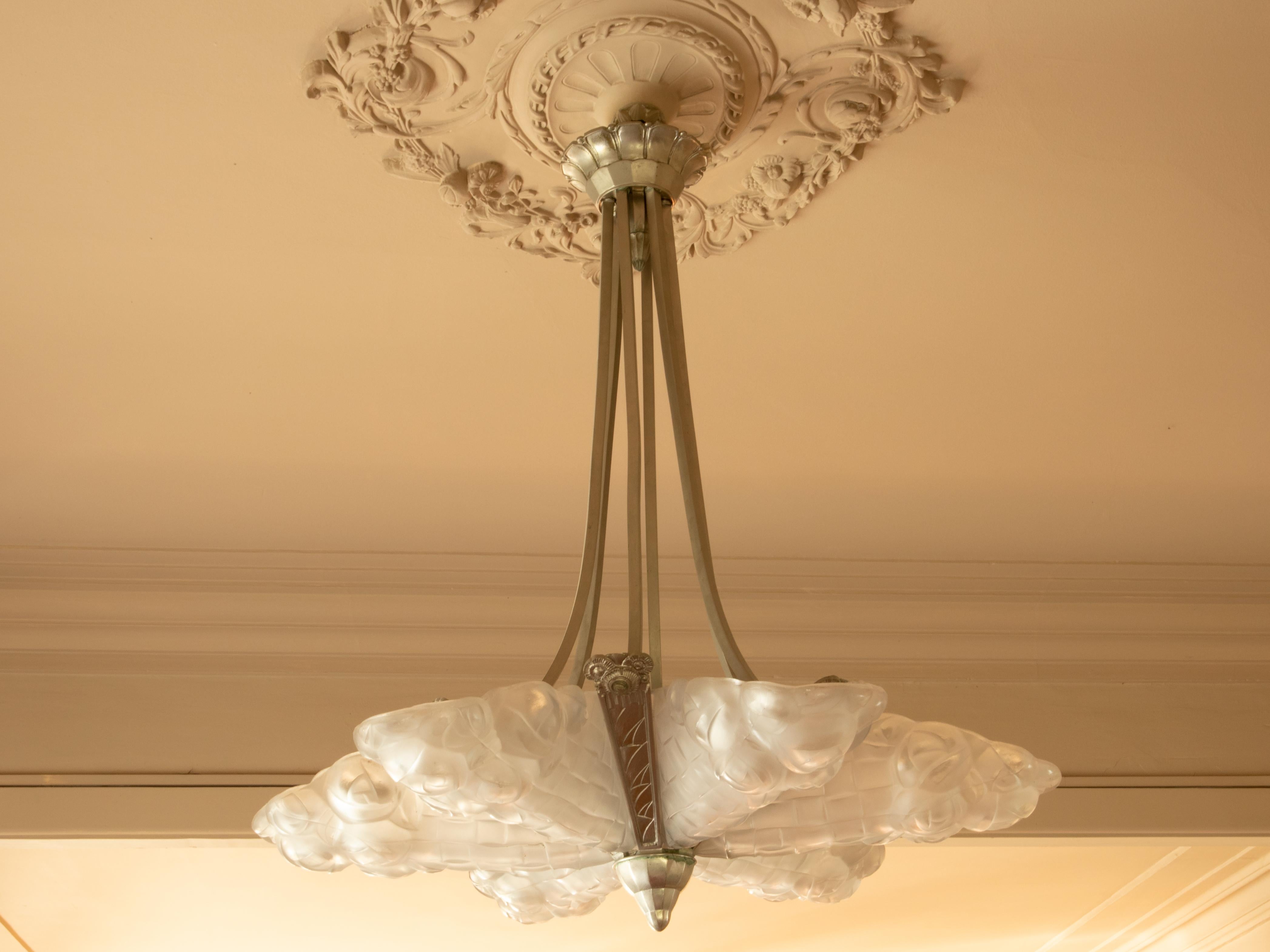 A French Art Deco chandelier by David Guéron Degué, featuring frosted glass panels, suspended from a nickel-plated frame. 
Crafted in the 1920s, this piece exemplifies the geometric elegance and refined craftsmanship of Parisian Art Deco