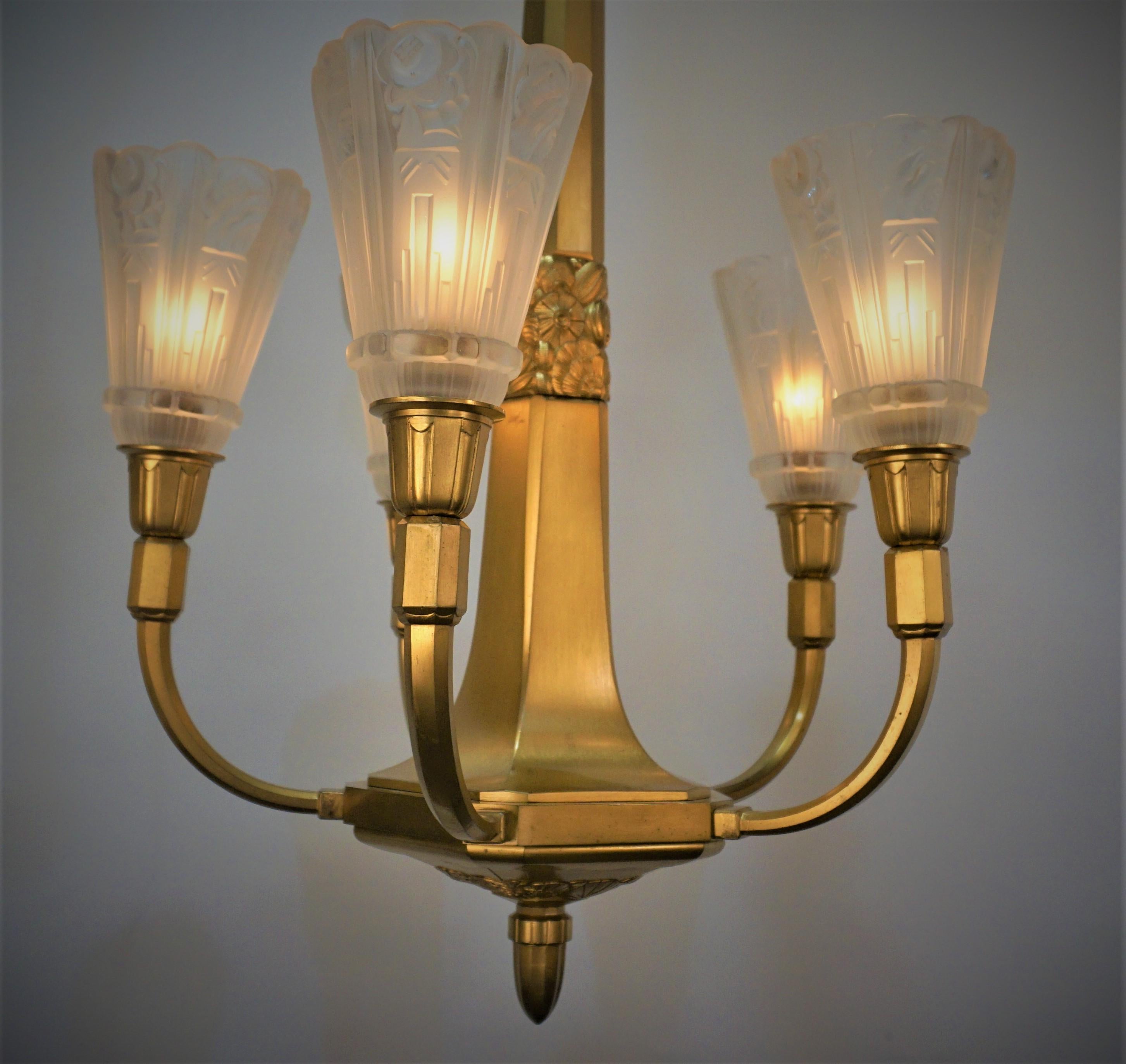 Superbe lustre Art Déco français à cinq lumières en verre givré clair, signé par J Robert. Superbe cadre en bronze doré.
Recâblage professionnel et prêt à être installé.