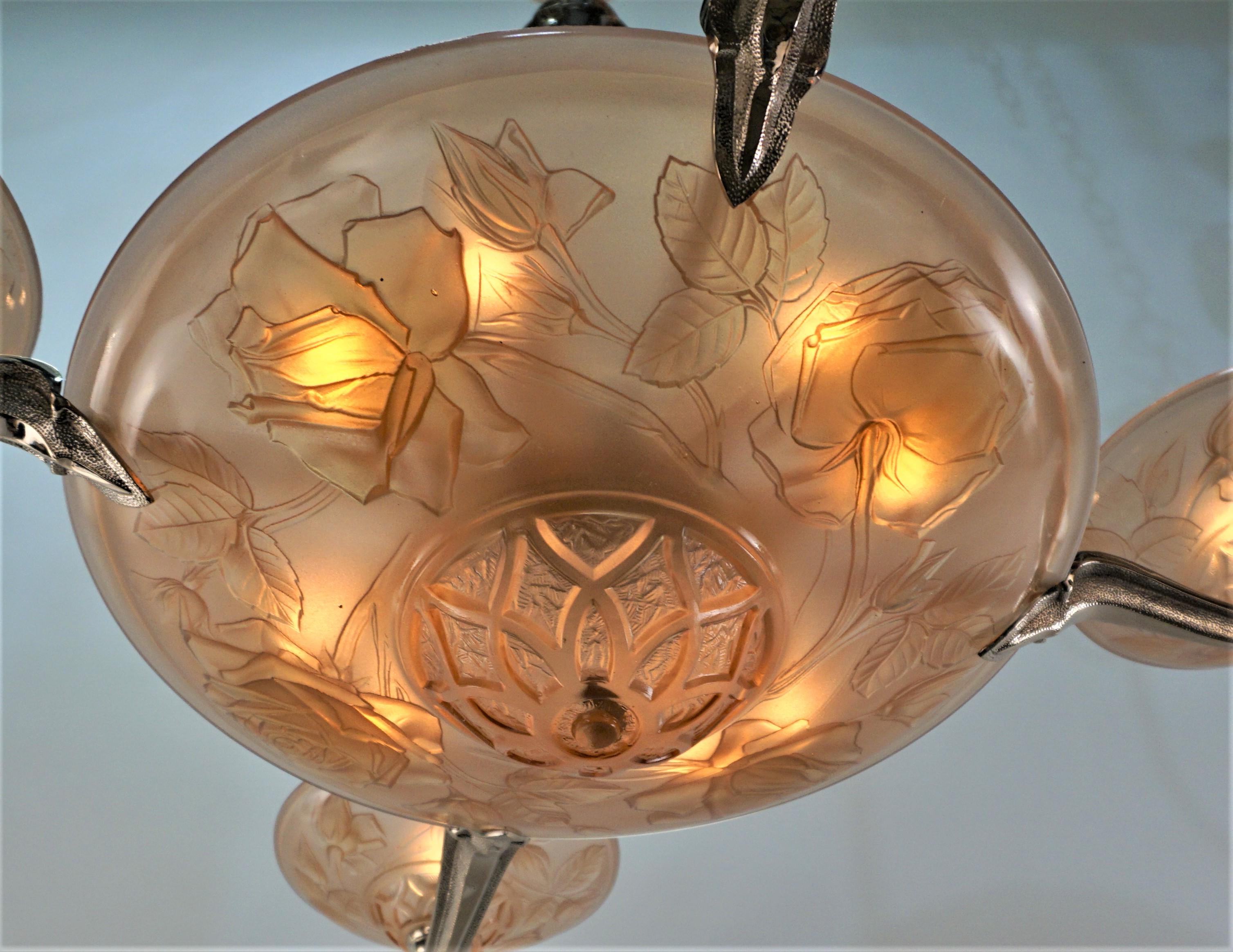 Beautiful molded-pressed rose peach color glass, large center bowel and four small for the sides.
Frame is nickel on bronze. 
This chandelier has new wiring with total of twelve lights max 60 watt each.
Width is 34
