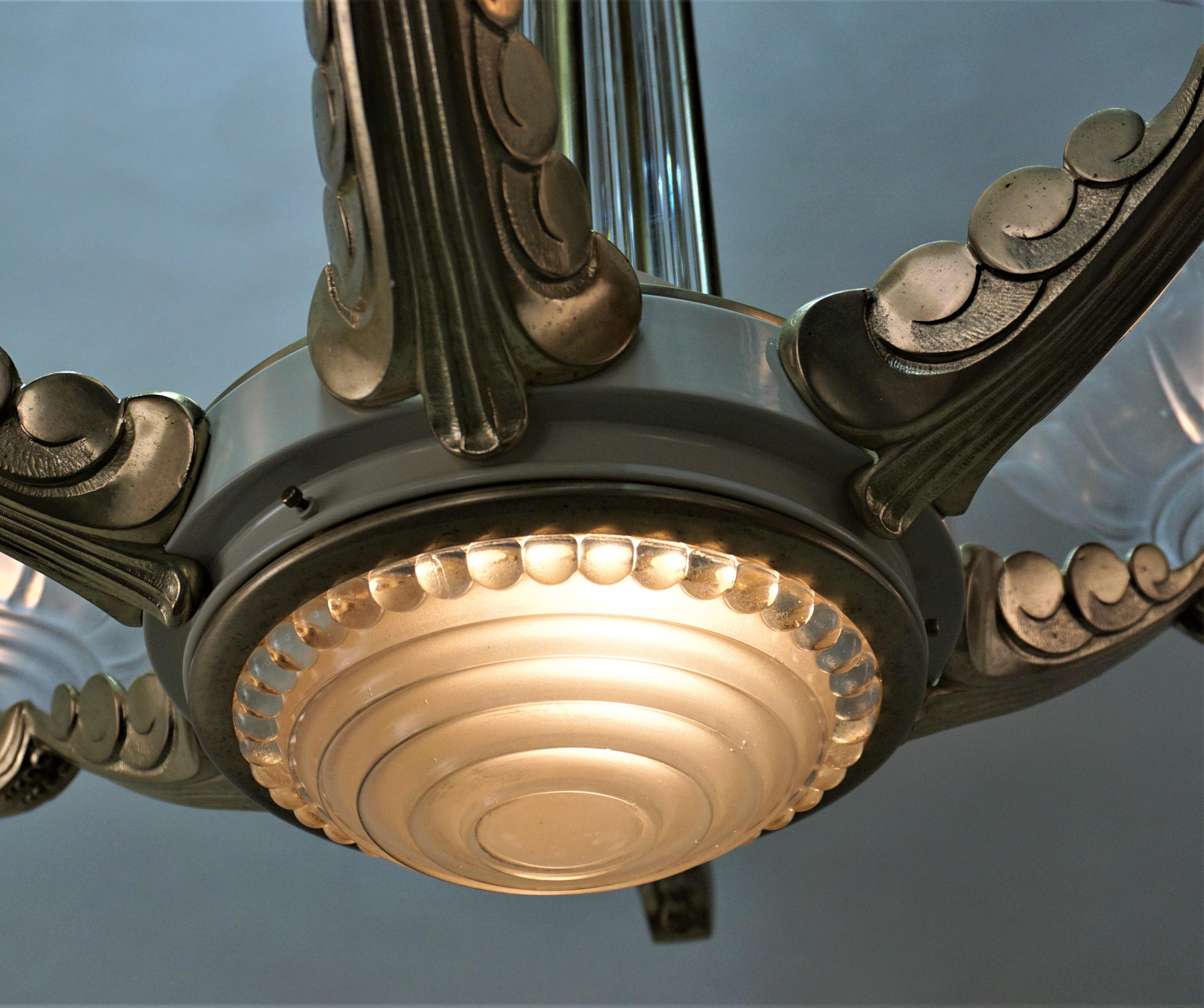 French Art Deco chandelier by Petitot. It features a bronze and lacquer on bronze frame with glass rods as a center column and molded glass shades.
Height is 42