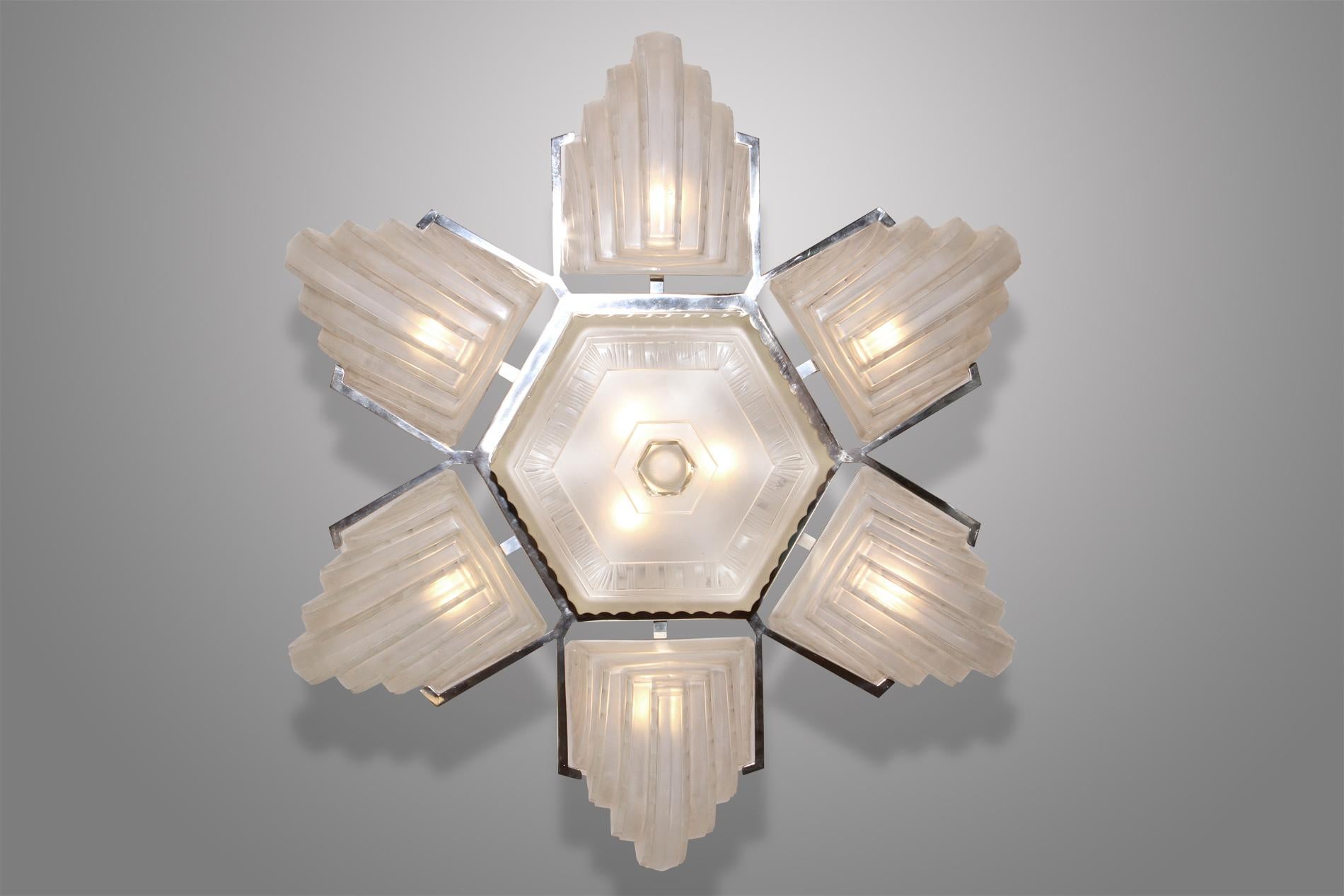 French art deco chandelier from 1930 made by the illustrious Sabino workshop in France around 1930. 

The chandelier presents a geometrical glass work and its linear forms is typical of the art deco period. The 7 glasses are attached to a