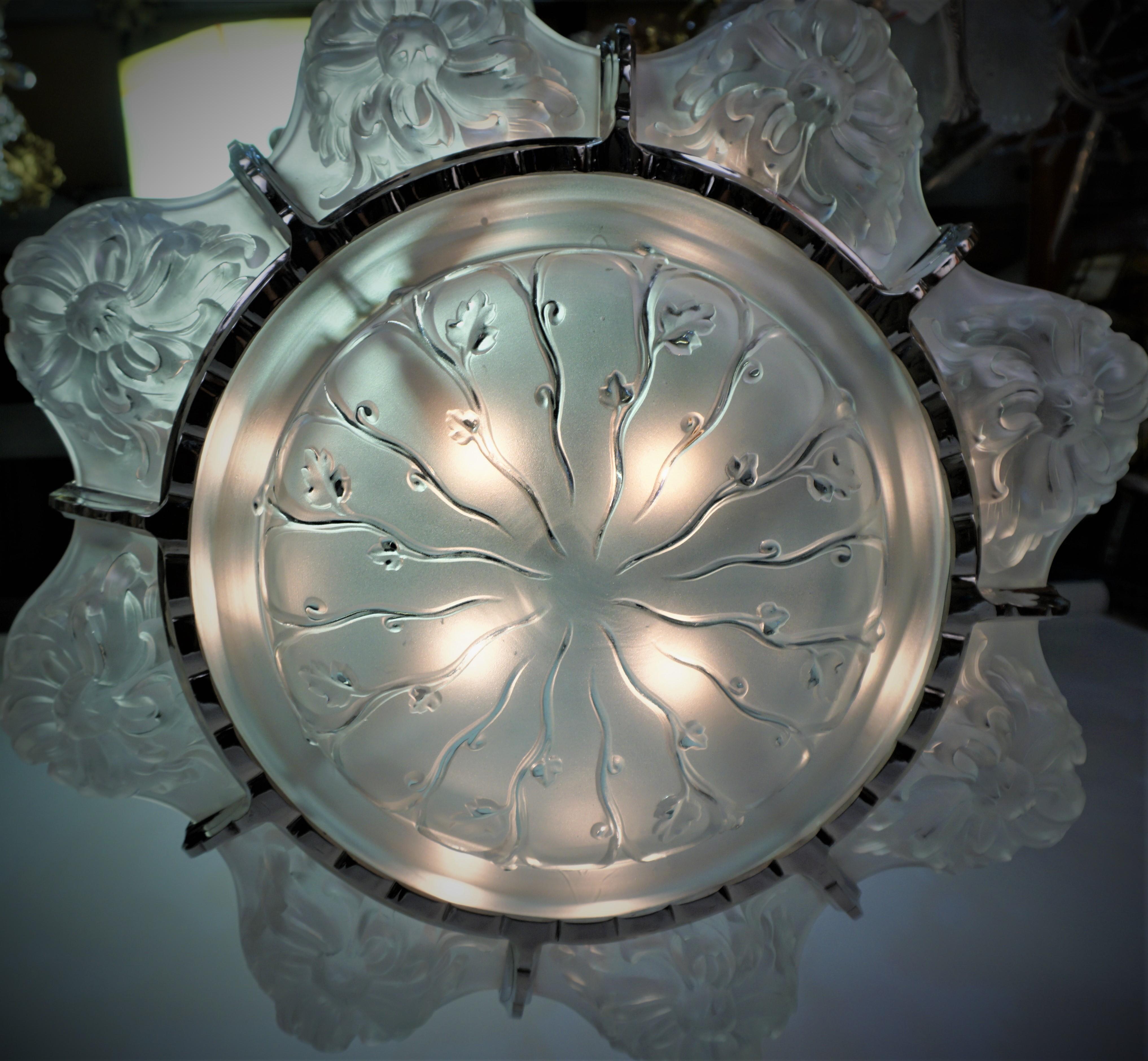 French Art Deco chandelier by Marius Ernest Sabino, one center and eight side glass in clear frost with nickel on bronze frame. 
Total 12 lights 75 watts max each.