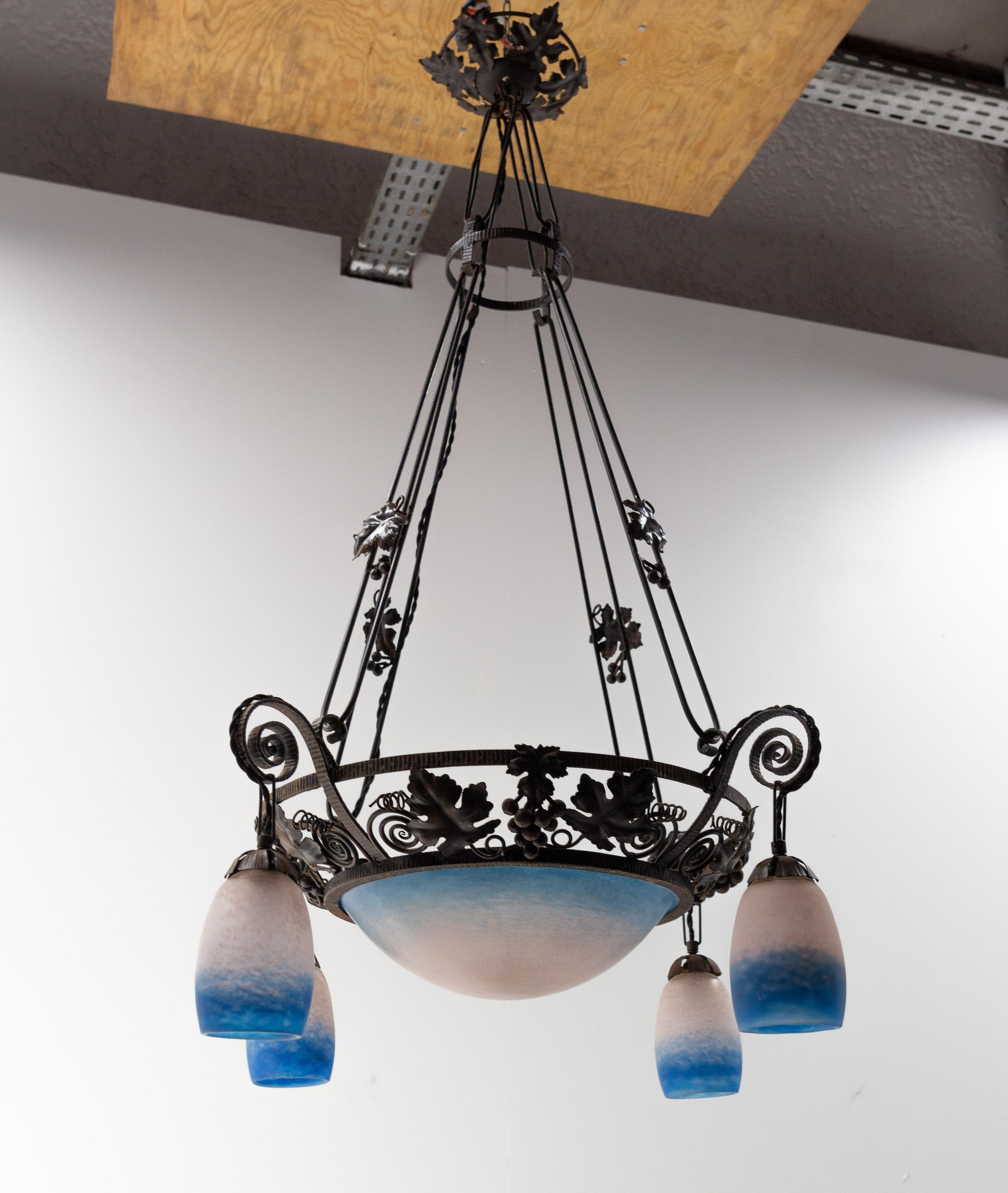 Art Deco chandelier or lustre, French
Molten glass and wrought iron ceiling pendant decorated of grape fruits and vine leaves.
Luminaire made circa 1930 during the art déco years. The glass tulips were made in the glass factory of Rethondes. This