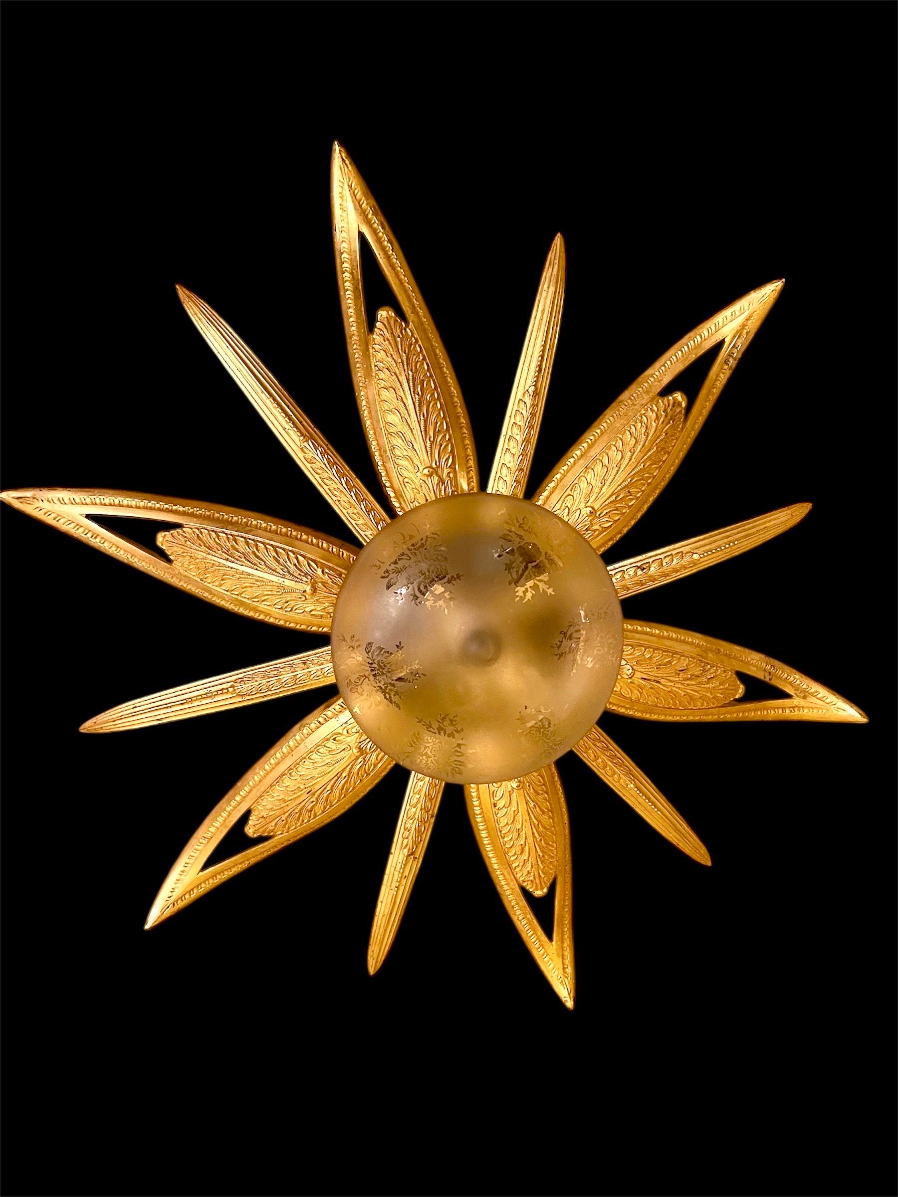 Exceptional Art Deco star-shaped chandelier in engraved bronze with original gilding, France, 1930s-1940s. Seven lights. This recessed fixture features a 100% original central glass globe composed of a star with six large engraved leaves and six