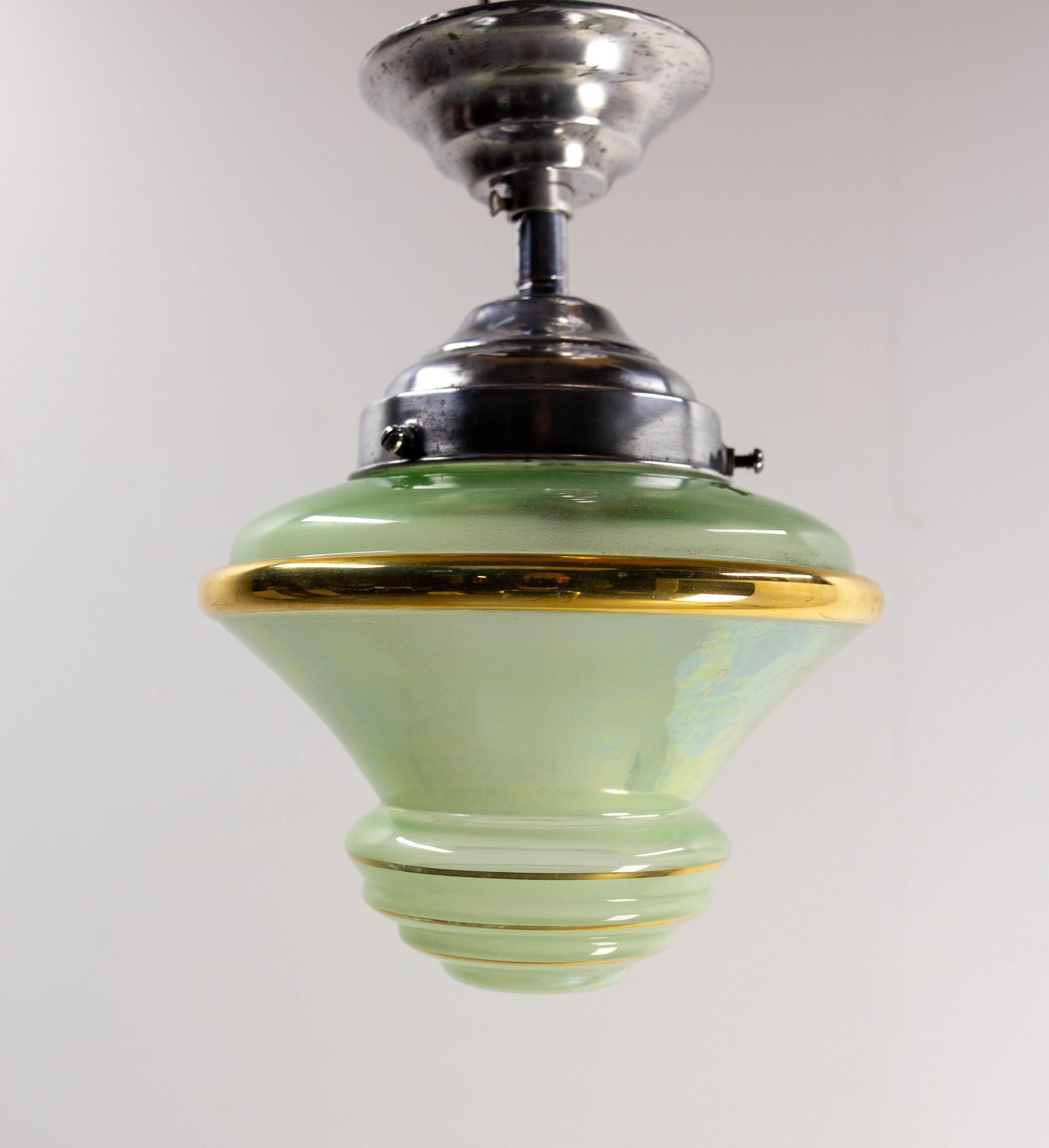 Iridescent glass and polished aluminum chandelier or lustre, French.
polished aluminum
The green glass is decorated with a line of gold paint.
Luminaire made circa 1920 in the Art Déco period. 

Good condition.
This is is adapted to USA or EU and UK