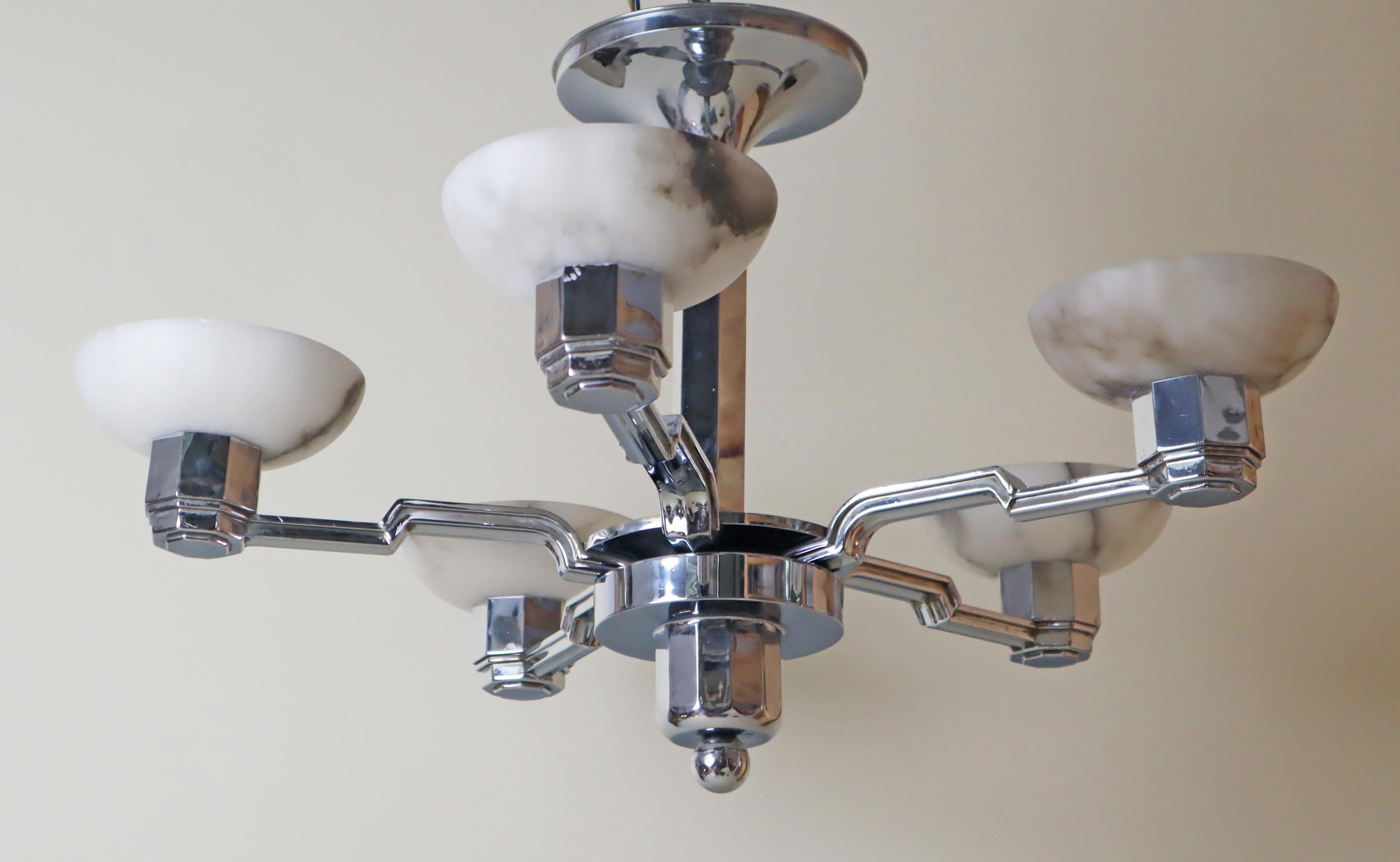 This Art Deco chandelier is a real gem! The way the chrome and alabaster come together is truly special — it's a rare combination, but they blend so beautifully. This lovely chandelier hails from France and was crafted especially for the German