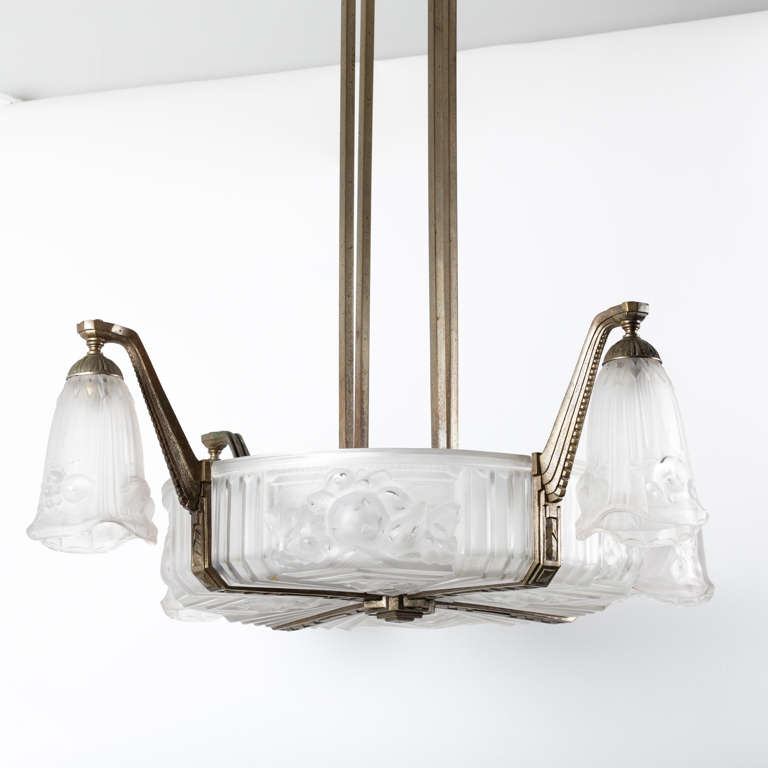 French art deco chandelier by Pierre Gilles

The object is rectilinear and austere in design, the round 4-piece centerpiece has 4 arms in the shape 
of an inverted flower.
The matte pressed glass features both geometric elements and floral elements.