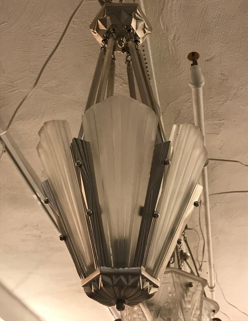 French Art Deco chandelier signed by famous artist Degué. Having six clear frosted glass panels with geometric motif details. Polished details on a nickel bronze geometric design frame. Height can be adjusted upon request. Has been rewired for