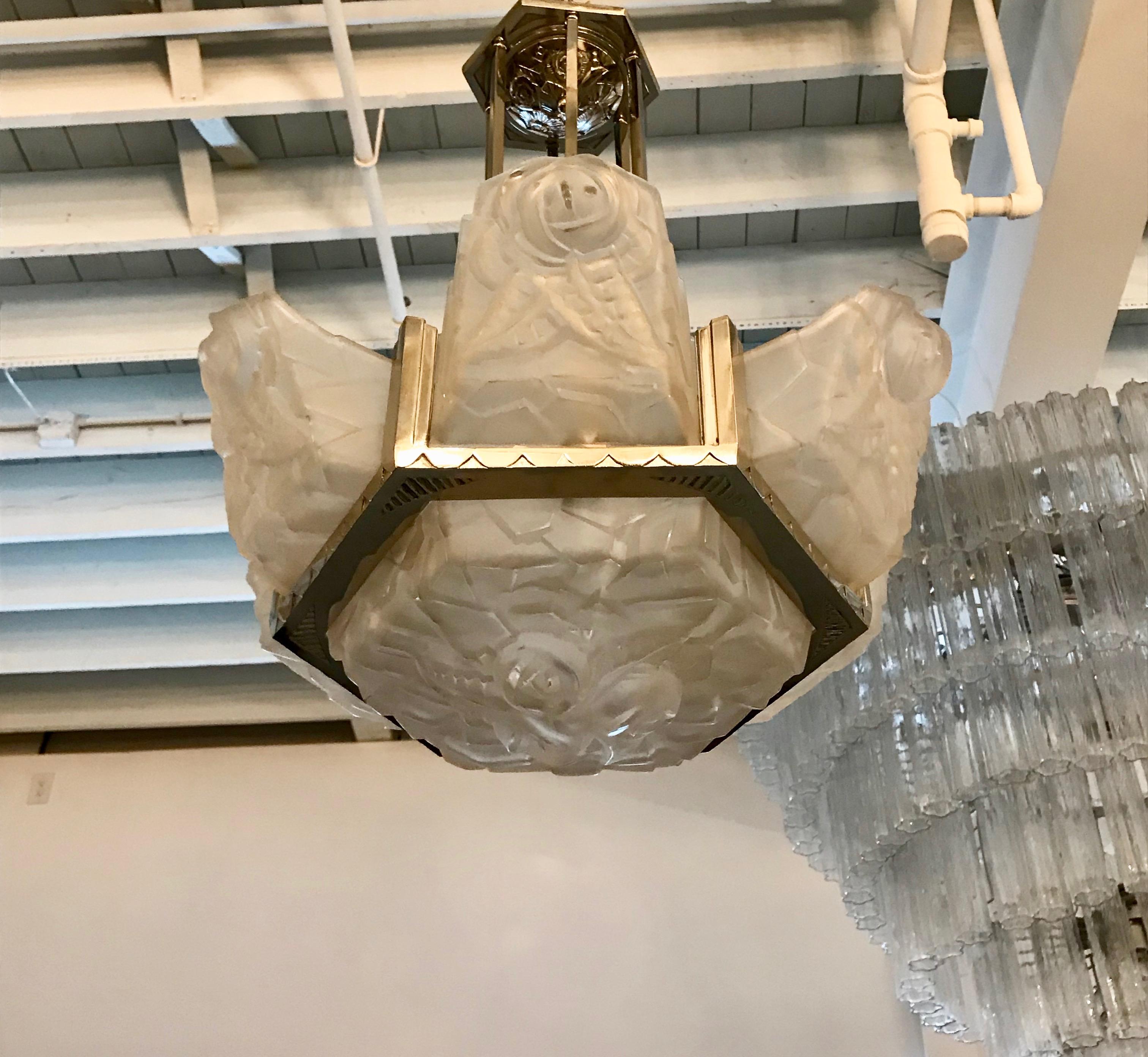 French Art Deco floral chandelier signed by Degué. Six outer clear frosted glass panels with floral motif with a matching centre glass bowl. Held by a streamline deco nickel polished design frame. The ceiling plate has a beautiful deco floral motif.